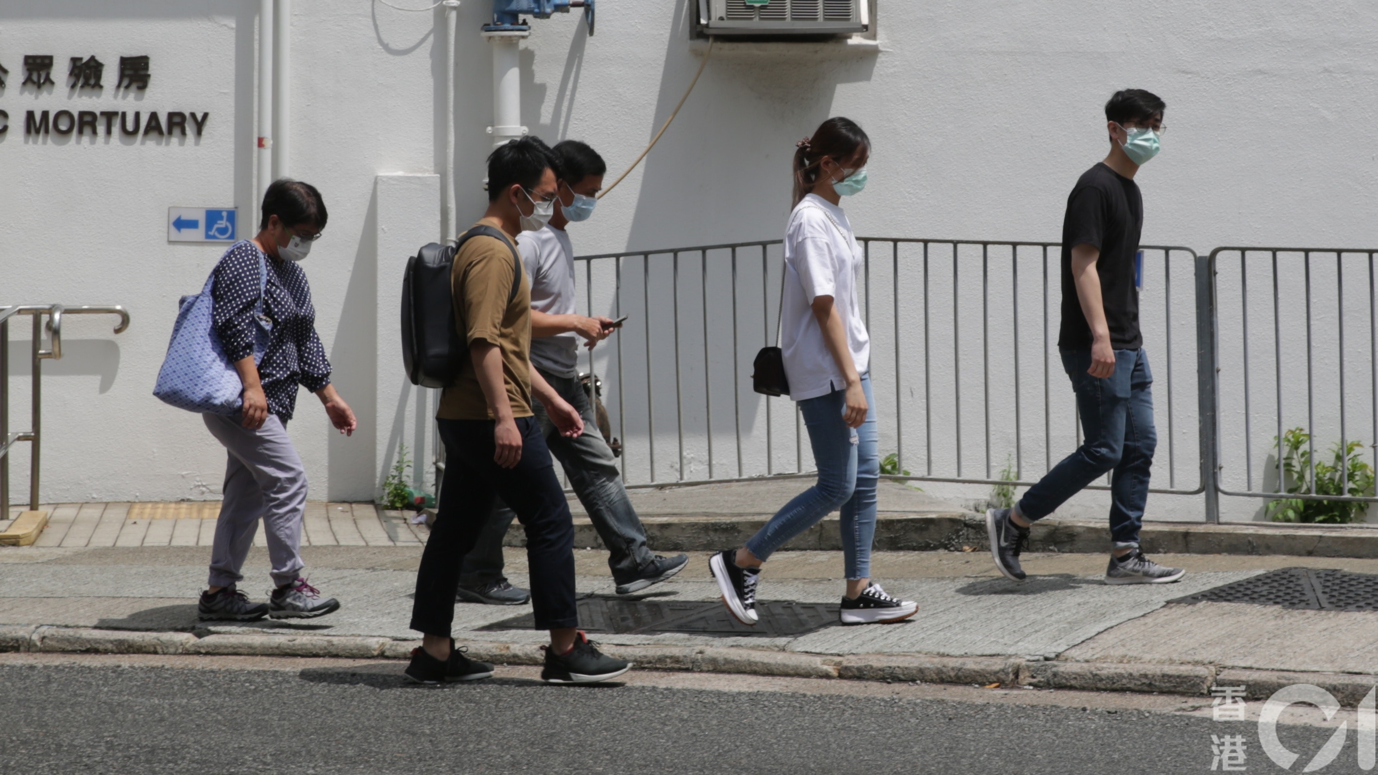 西環康文署修樹工一死一傷工業意外，55歲女死者曾賽茹家人今（19日）上午10時許到域多利亞公眾殮房認屍，神情哀傷，相擁而泣。（黃偉民攝）