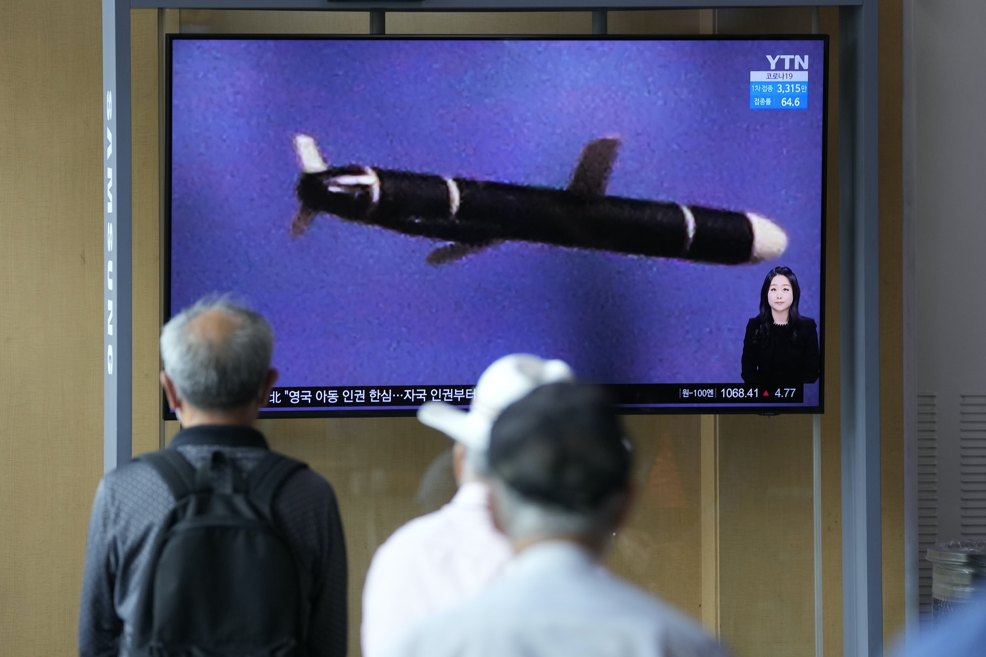 朝鲜导弹：图为2021年9月13日，身在韩国首尔的人观看电视荧幕，新闻报道正在展示9月11日至12日朝鲜成功试射长程巡航导弹的影像。 （AP）