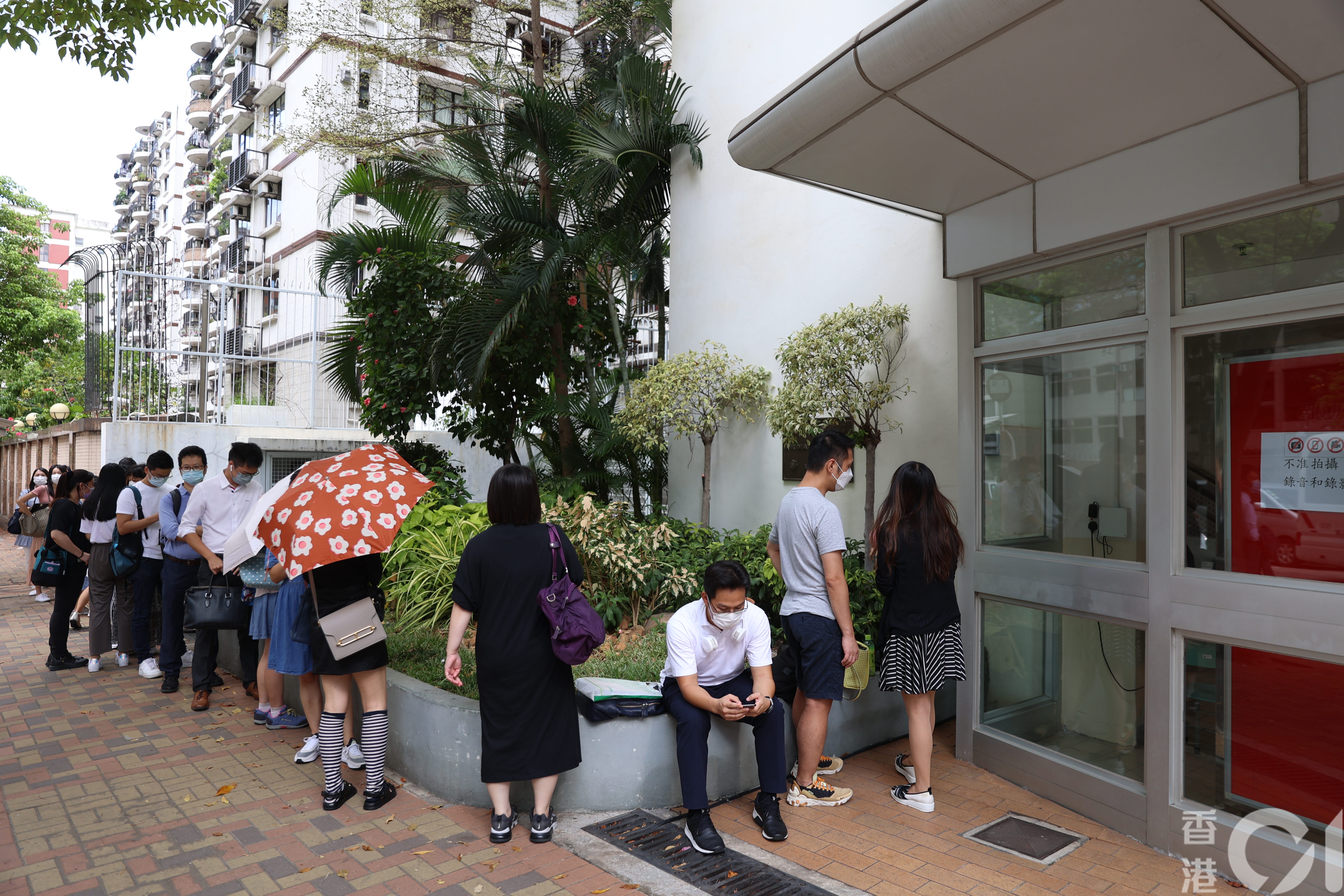 喇沙小學今早9時才開始收表，此前已有約20名家長於校門外排隊等候。 （鄭子峰攝）