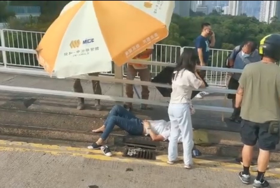 有熱心途人更為她撐傘擋太陽。（網上影片截圖）