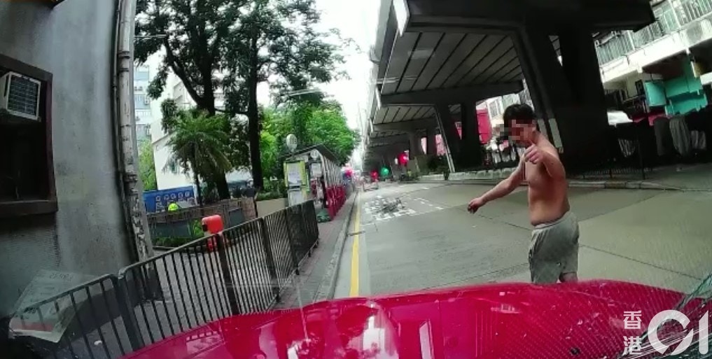 單車男扑向的士擋風玻璃近20秒，之後他憤怒地離開取回單車，他一度向的士司機肇起拇指及指向地下。（讀者提供影片截圖）