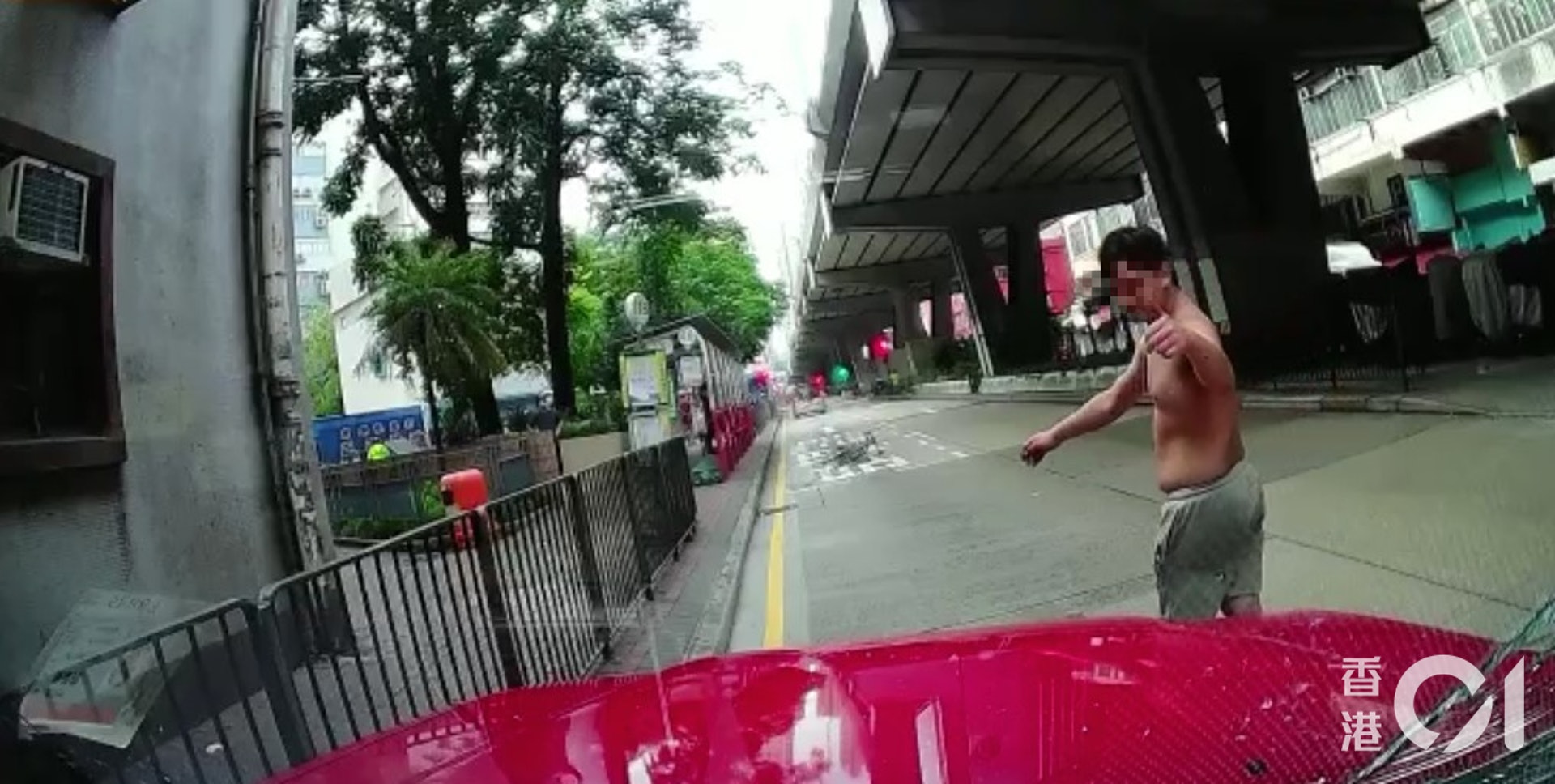 單車男扑向的士擋風玻璃近20秒,之後他憤怒地離開取回單車,他一度向的士司機肇起拇指及指向地下。(讀者提供影片截圖)