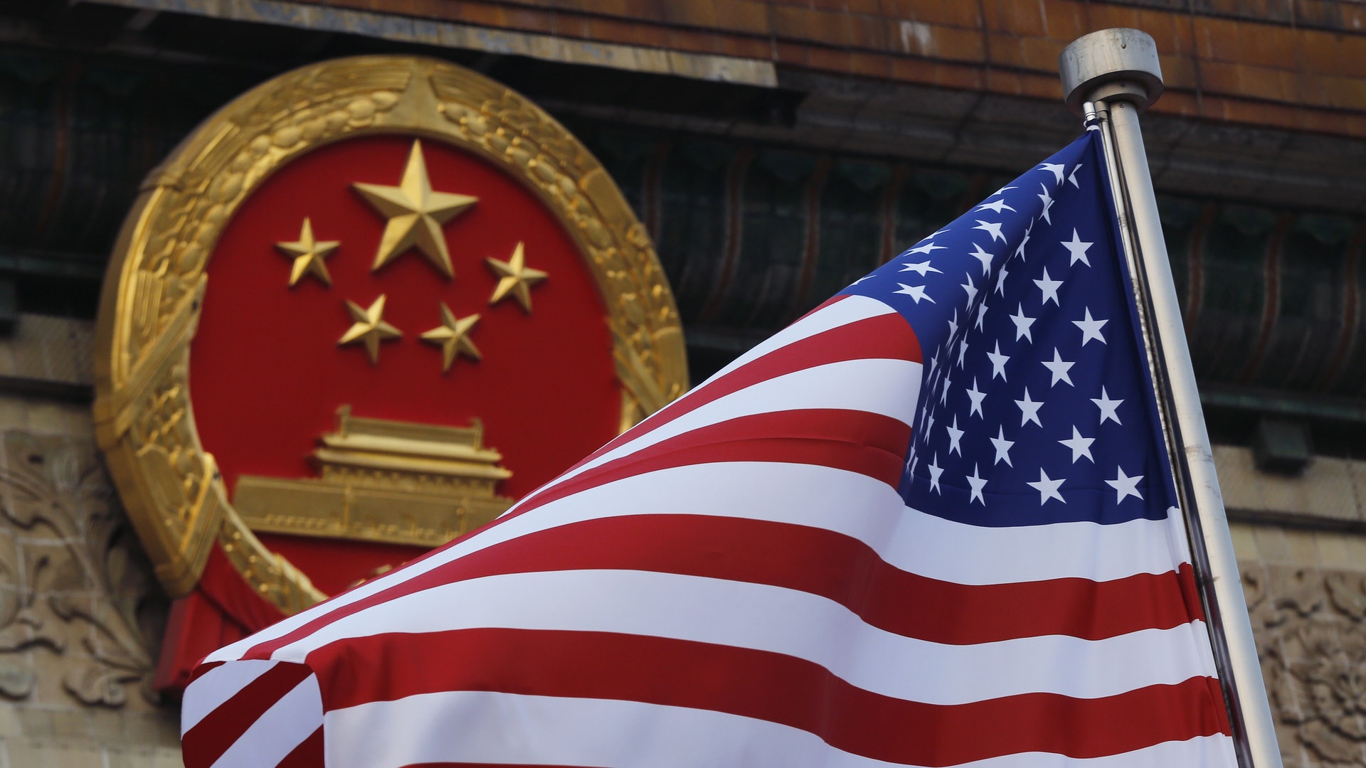 中美關係：圖為2017年11月9日，中國北京的中國國徽與美國國旗。（AP）