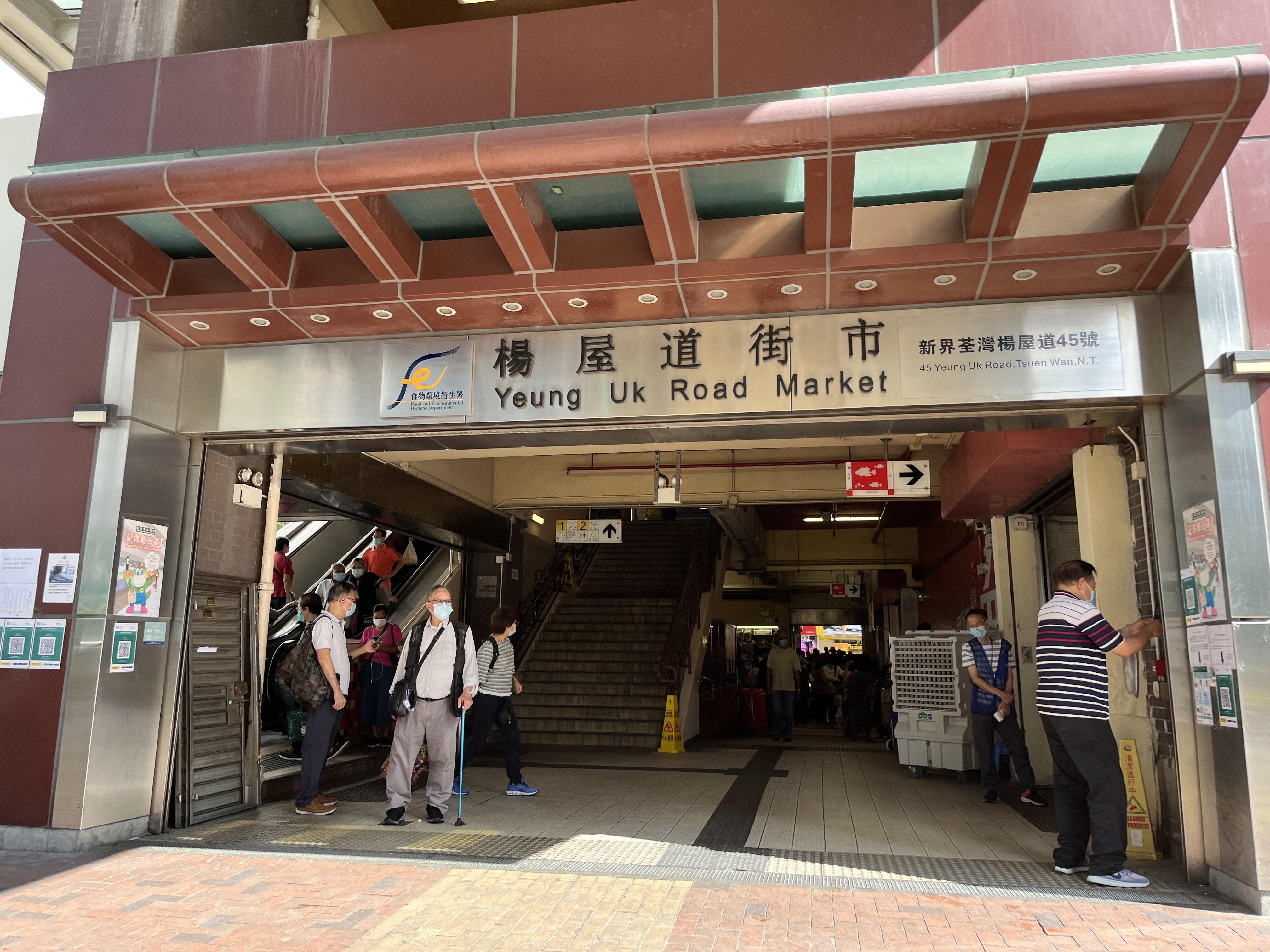 荃灣楊屋道街市多個出入口均有職員協助市民使用「安心出行」或填寫個人資料，亦有市民會將身份證遞上讓職員代為填寫，有長者表示，因為沒有智能手機而無法使用應用程式，慨嘆新措施麻煩又不便。（黎倩婷攝）