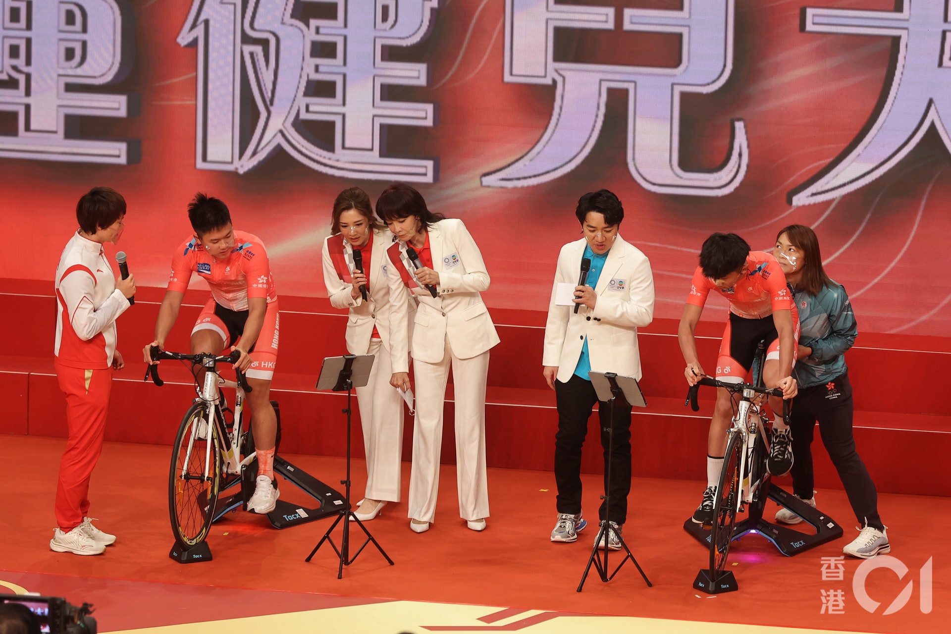 李慧詩與鍾天使從旁指導後輩踩室內單車,其中一架室內單車懷疑「裝得唔夠實」,需由李慧詩在旁扶實以完成表演。(李澤彤攝) 李慧詩與鍾天使從旁指導後輩踩室內單車,其中一架室內單車懷疑「裝得唔夠實」,需由李慧詩在旁扶實以完成表演。(李澤彤攝)