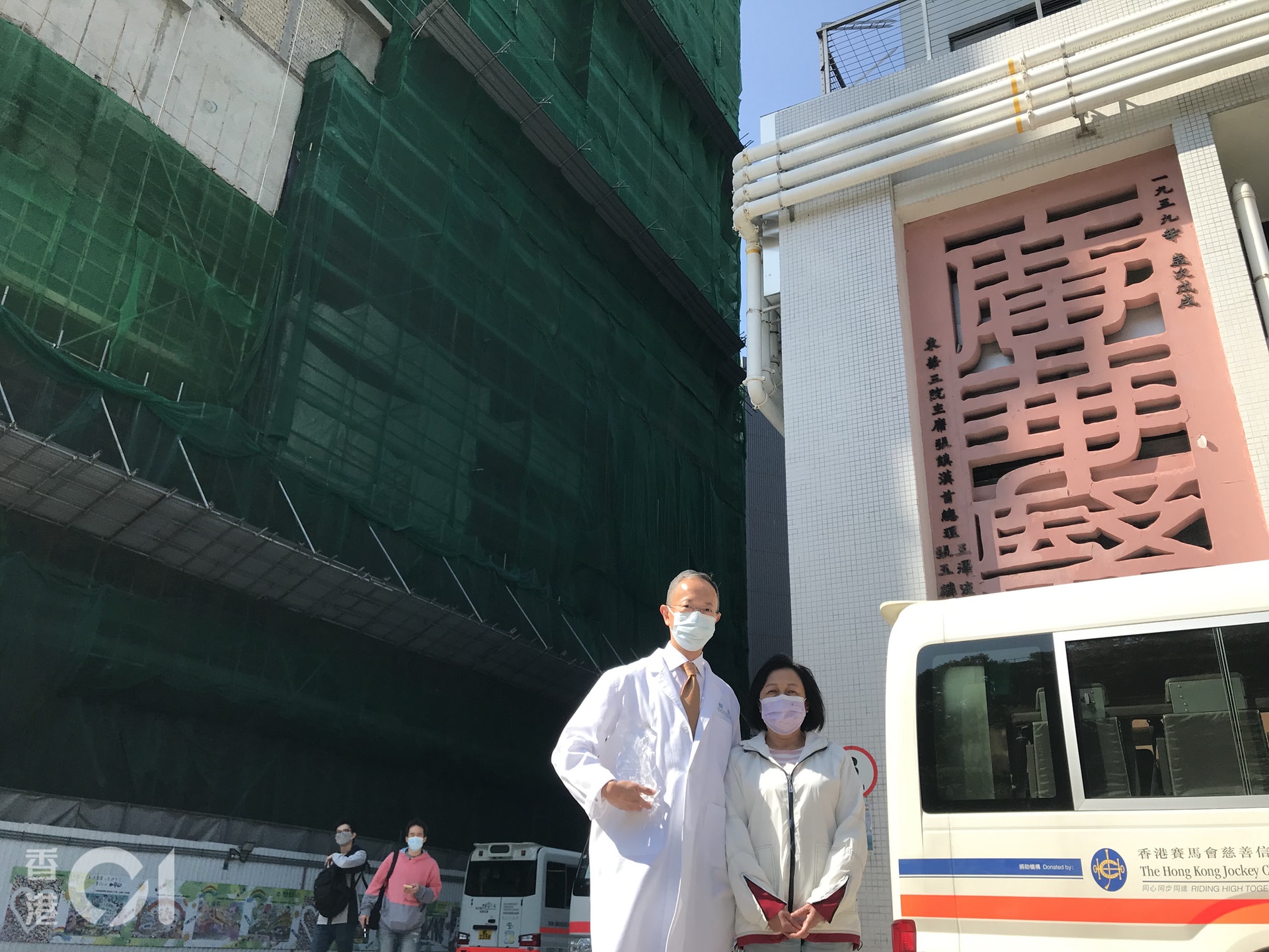 廣華醫院第一期的新大樓(相片左方正興建的大樓)有望在2022年底或2023年初啟用。 相片右方是現時正使用的大樓。左為麥肇嘉醫生、右為病人梁太。 (鄭翠碧攝) 廣華醫院第一期的新大樓(相片左方正興建的大樓)有望在2022年底或2023年初啟用。 相片右方是現時正使用的大樓。左為麥肇嘉醫生、右為病人梁太。 (鄭翠碧攝)