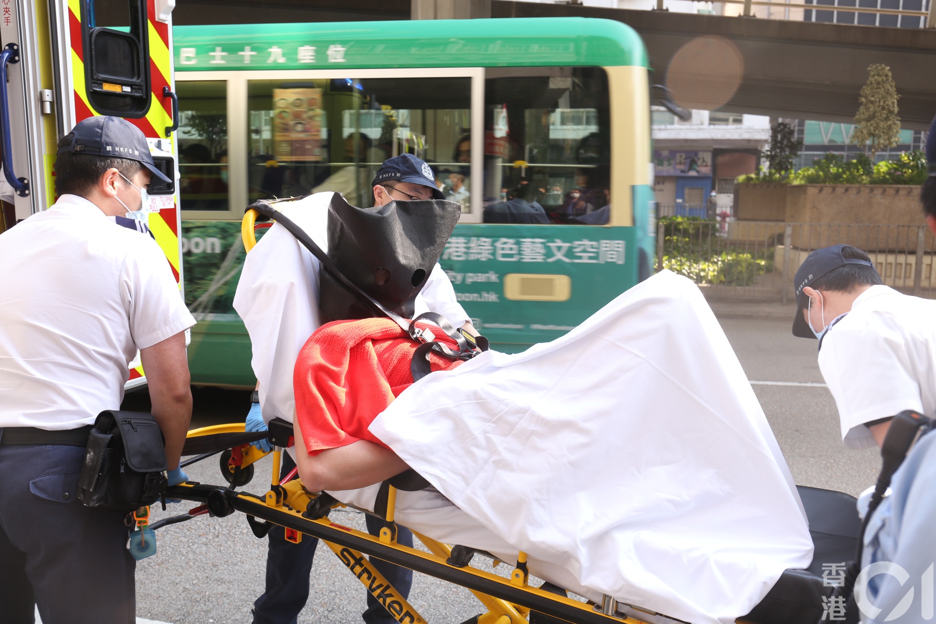 警員掩至將其兇徒拘捕，兇徒黑布蒙頭，需由擔架床送上救護車。（陳浠文攝）