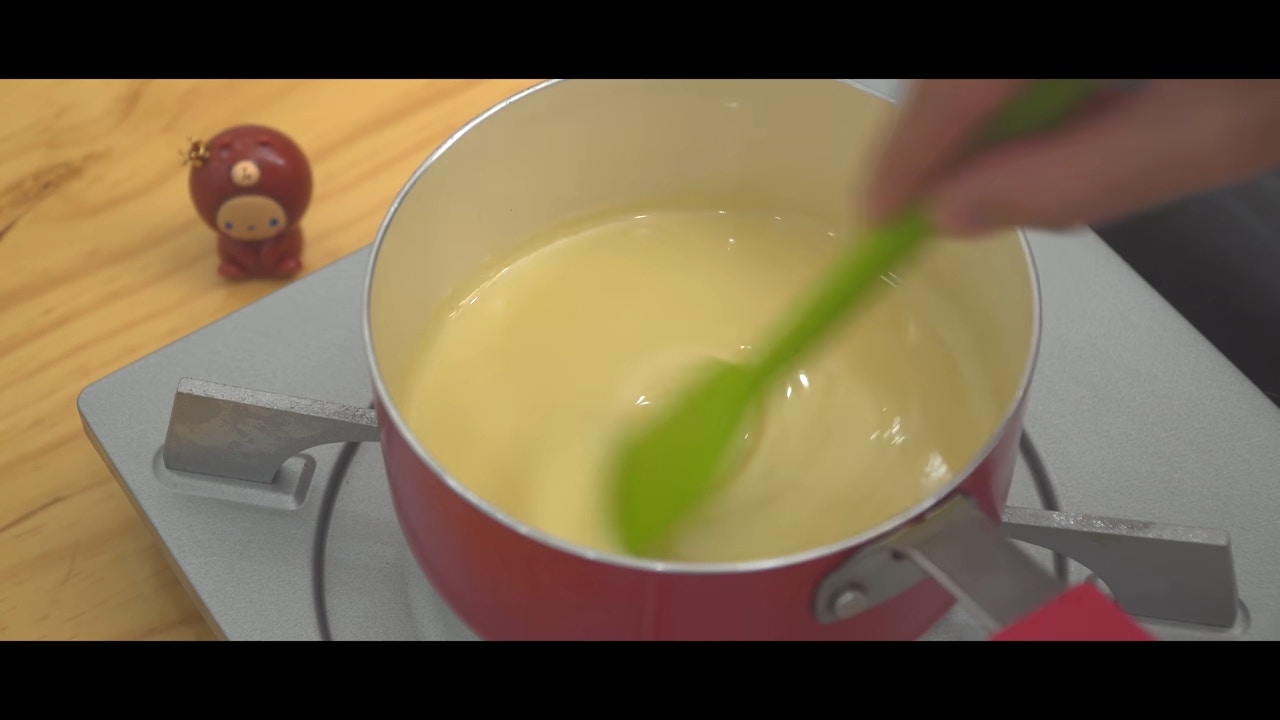 煉奶於鍋中加熱，邊煮邊攪。（影片截圖：Nino's home）