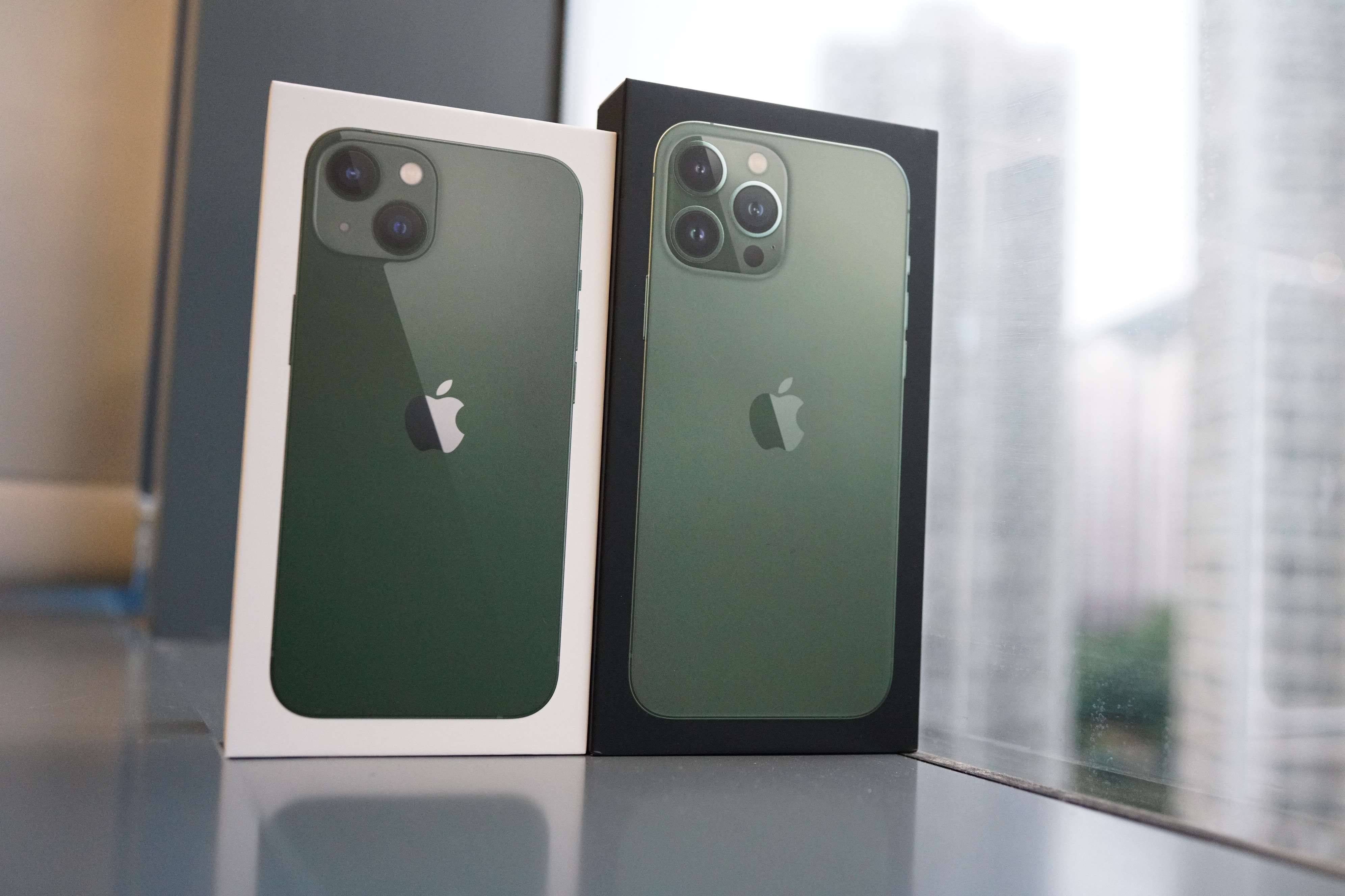 看iPhone 13及13 Pro Max的外盒，滿以為2款綠色都是一樣，開箱後便會發現完全不同。（林勇攝）