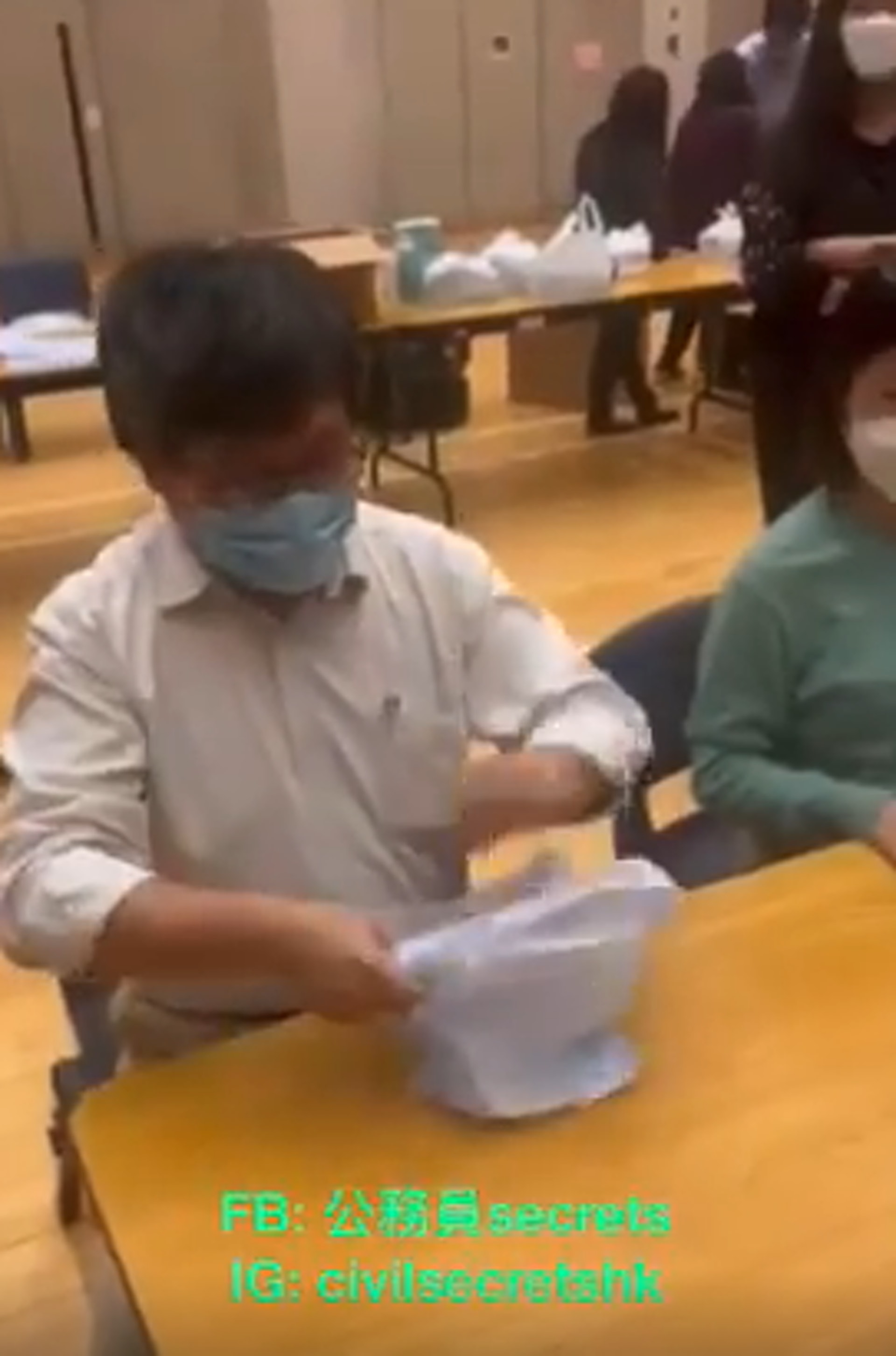 從影片可見,工作人員先將快速抗原測試包、口罩、中成藥和醫療資訊分開擺放在1張長枱上,每項物資都有負責人員,將該項物資入白色膠袋,就傳給下一個人。(FB「公務員secrets」影片截圖) 從影片可見,工作人員先將快速抗原測試包、口罩、中成藥和醫療資訊分開擺放在1張長枱上,每項物資都有負責人員,將該項物資入白色膠袋,就傳給下一個人。(FB「公務員secrets」影片截圖)