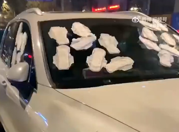 內地1名女車主的座駕遭1輛違例停泊的保時捷房車擋住達3小時，一怒之下到便利店買了多包衛生巾，貼滿保時捷的擋風玻璃及側車窗發泄。（微博影片截圖）