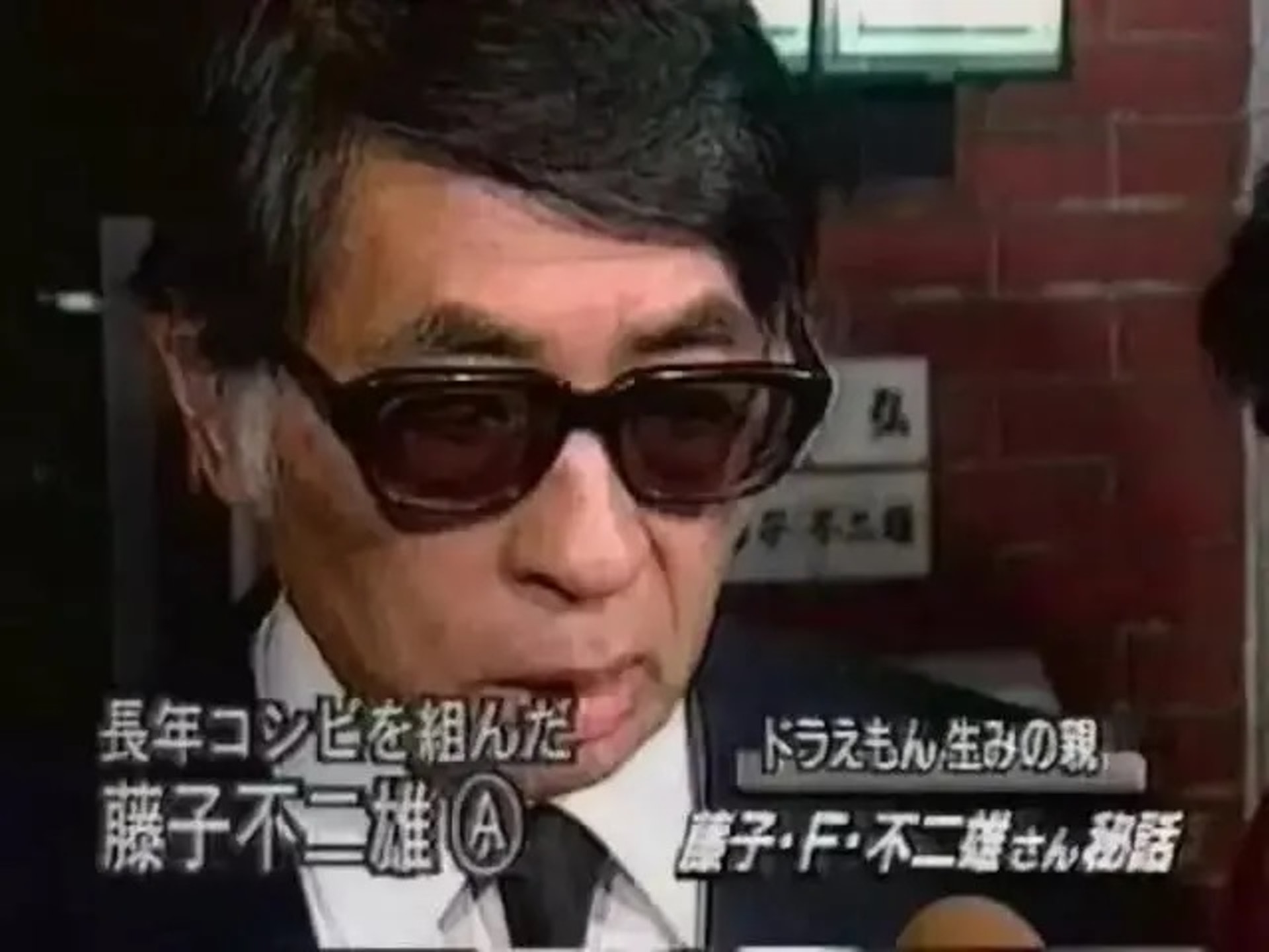 圖為1996年9月，藤本弘逝世，安孫子在葬禮接受訪問。（Youtube截圖）