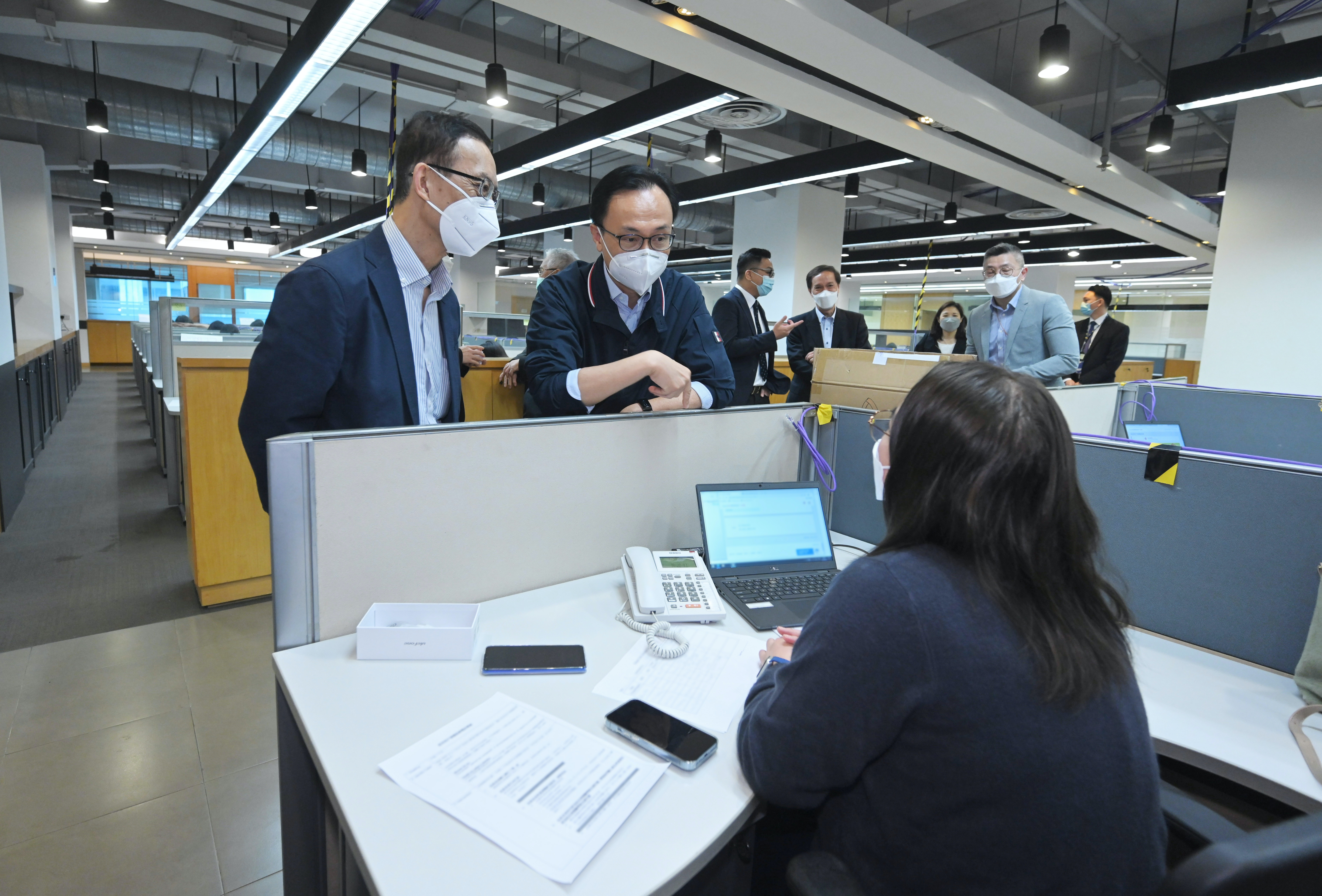 「疫苗到戶接種服務」4月19日起接受網上和電話登記。公務員事務局局長聶德權（右一）與工作人員交談，了解他們的工作。旁為明愛專上學院健康科學院院長陳磊石教授（右二）。（政府新聞處圖片)