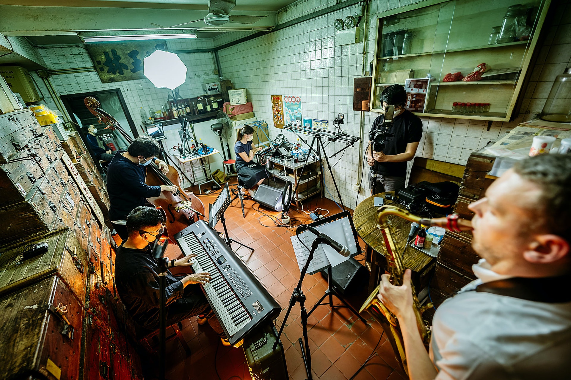 由香港藝術發展局資助的項目「爵士由地至上」,一連四個月將原創爵士音樂注入社區,在四間極具本土特色的店舖舉行線上直播,讓觀眾可以在社交平台上免費收看,音樂會選址在「蛇王林」、「公利真料竹蔗水」、「流動架生房」、「源興隆麵家」。(Innonation Studio提供圖片) 由香港藝術發展局資助的項目「爵士由地至上」,一連四個月將原創爵士音樂注入社區,在四間極具本土特色的店舖舉行線上直播,讓觀眾可以在社交平台上免費收看,音樂會選址在「蛇王林」、「公利真料竹蔗水」、「流動架生房」、「源興隆麵家」。(Innonation Studio提供圖片)