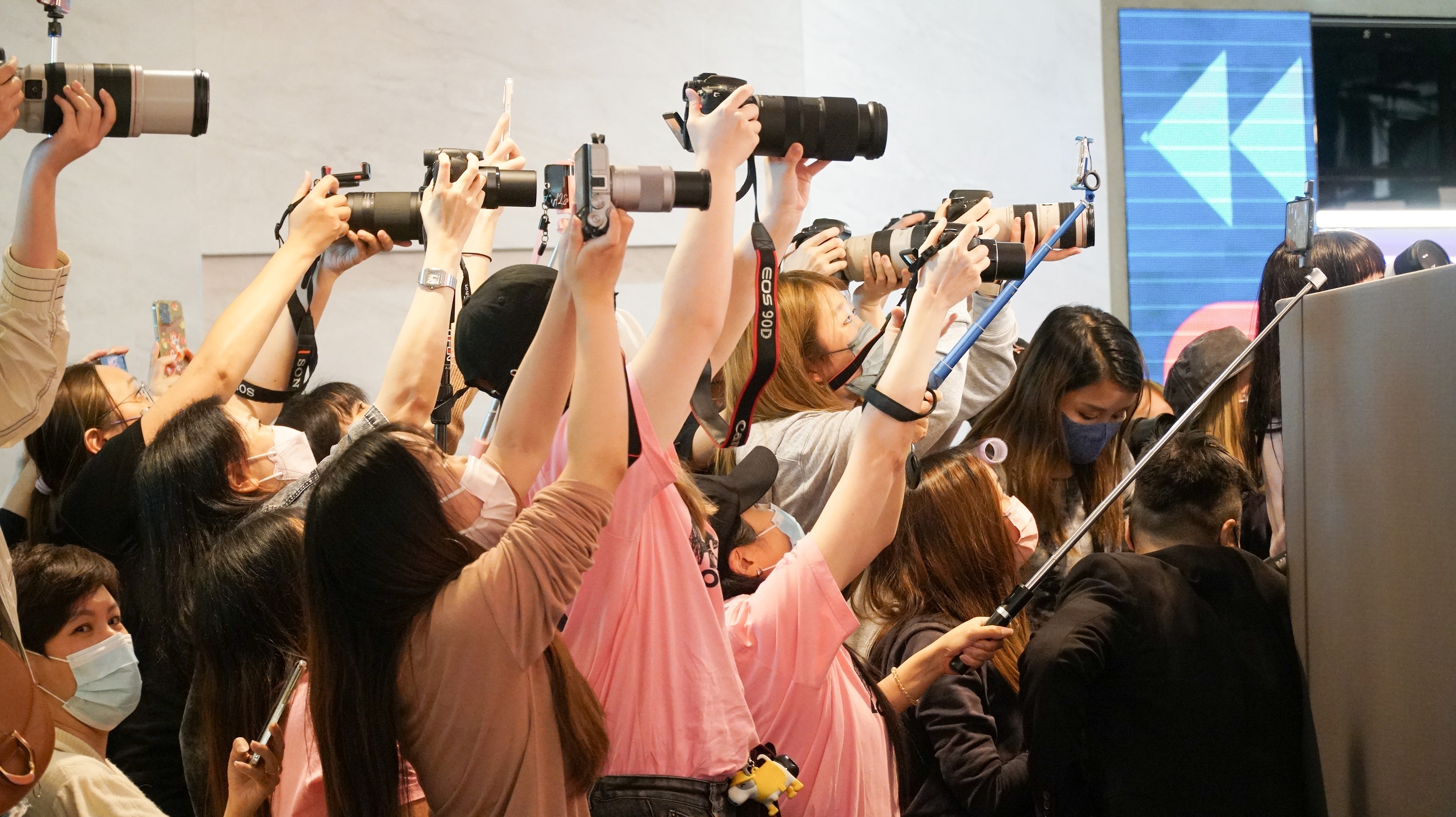 由於店舖圍上隔版以及長布阻擋視線，神徒紛紛借助自拍神棍的幫助，舉高相機拍攝在內情況。（鄺鈺瑩攝）