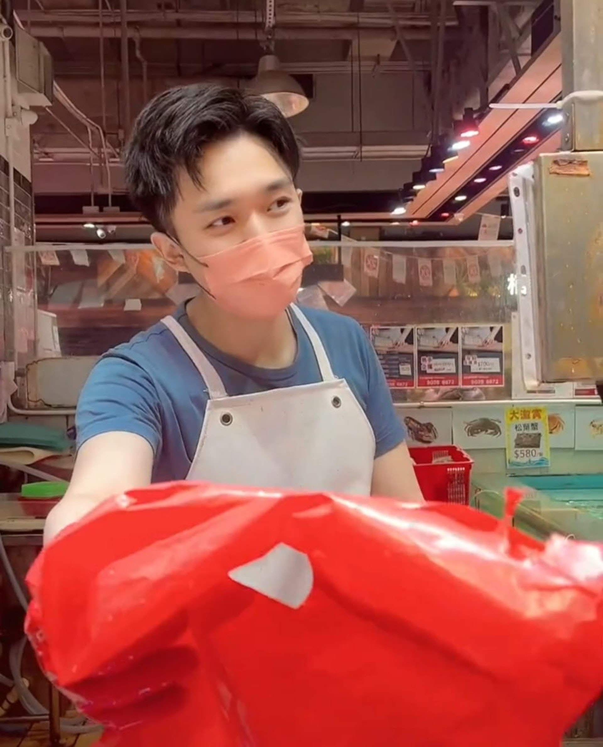 從照片可見,該身穿藍色短袖T恤的男員工外貌年輕,皮膚白晢,擁有一雙黑白分明的笑眼,行「青靚白淨書生」路線同樣深得師奶喜愛。(facebook群組「荃灣人」圖片)