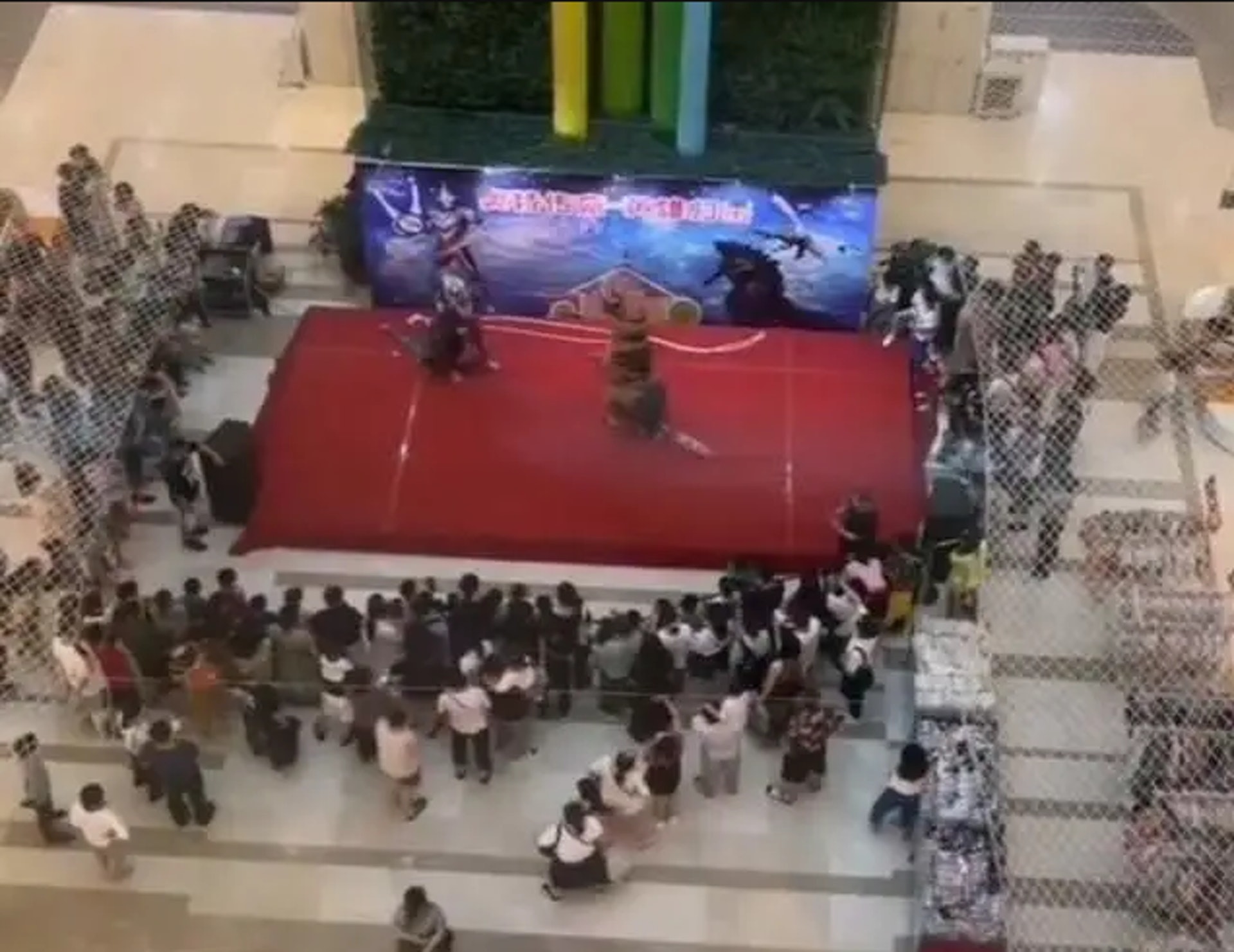 影片顯示,初時2個裝扮成怪獸的演員及穿上超人服的演員在台上大打出手,吸引過百人圍觀,大部分都是家長和孩子。(影片截圖) 影片顯示,初時2個裝扮成怪獸的演員及穿上超人服的演員在台上大打出手,吸引過百人圍觀,大部分都是家長和孩子。(影片截圖)