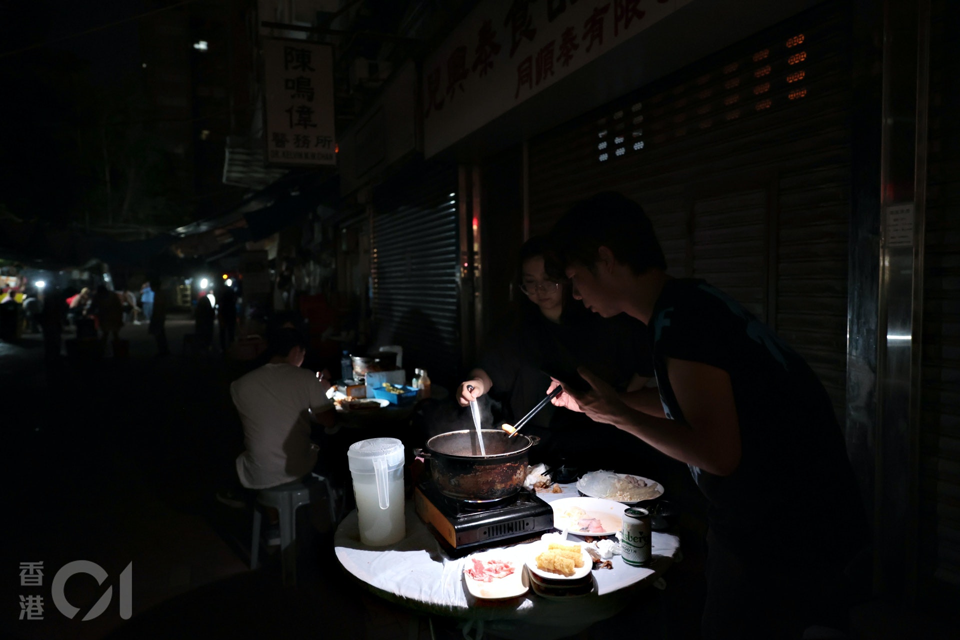 6月21日，有元朗市民在手提電話燈光下繼續用膳。（歐喜樂攝）