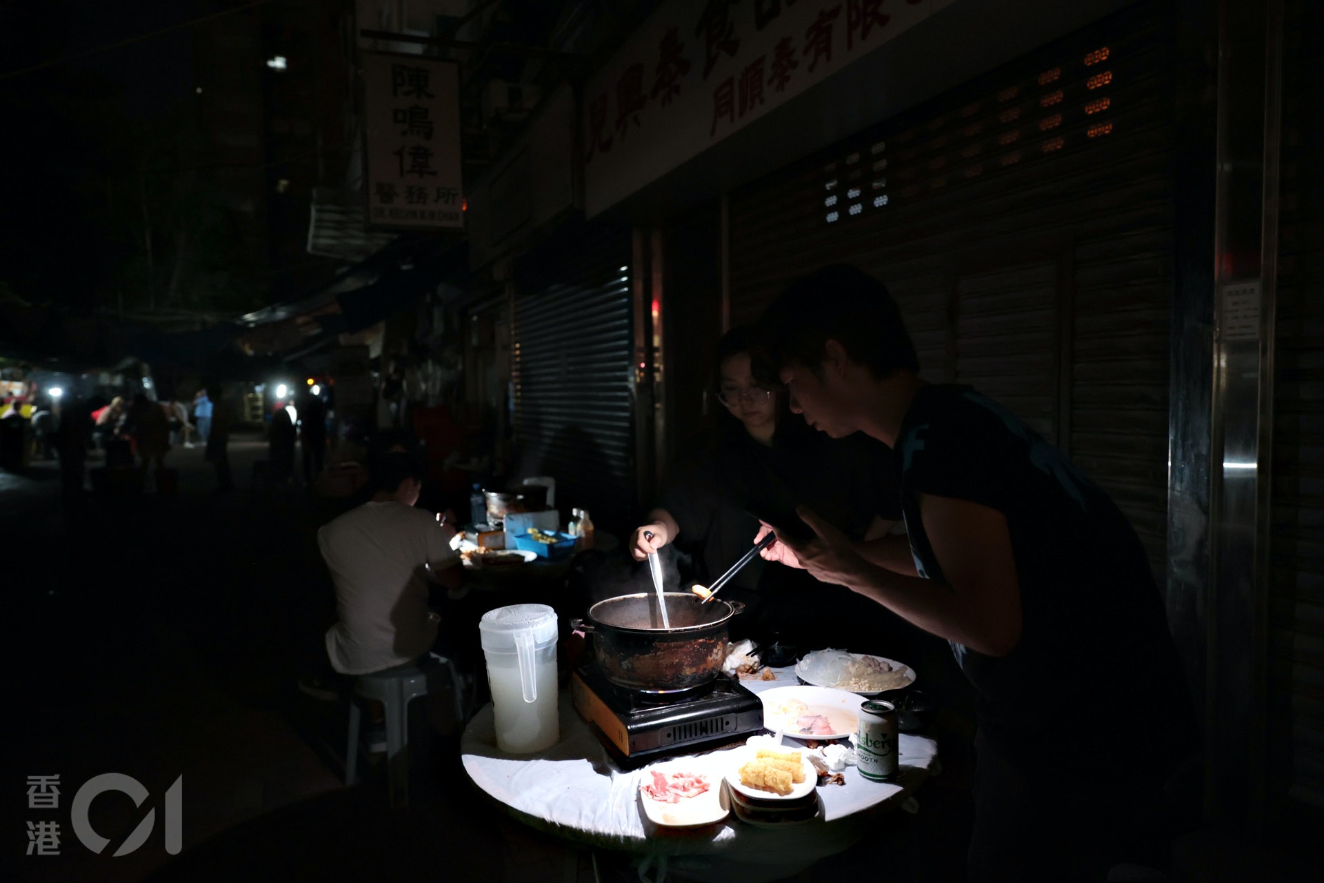6月21日,有元朗市民在手提電話燈光下繼續用膳。(歐喜樂攝) 6月21日,有元朗市民在手提電話燈光下繼續用膳。(歐喜樂攝)