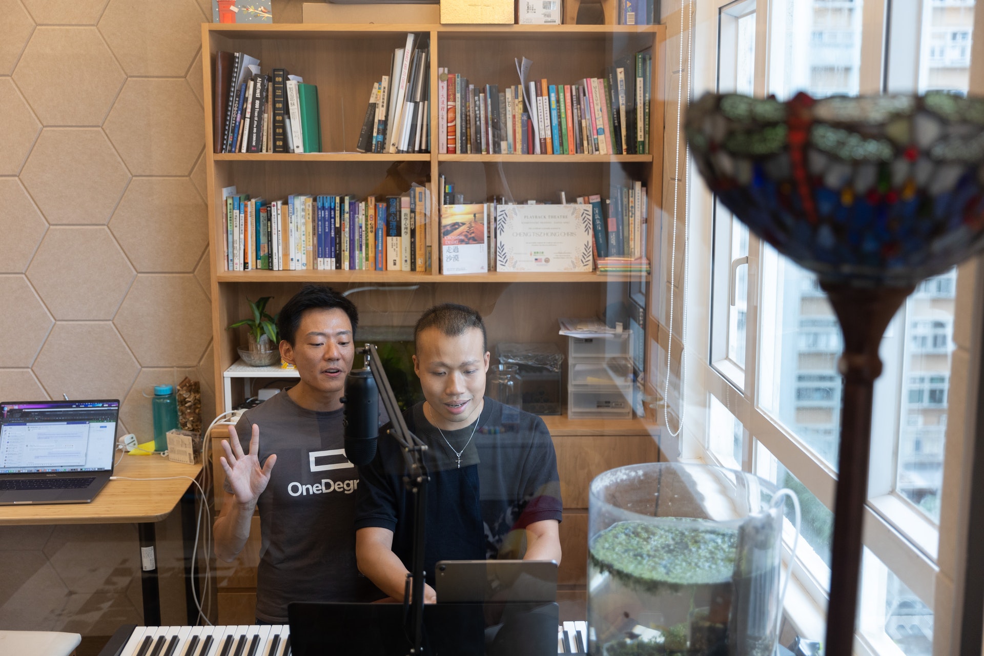 本來正在工作的Alan(左),聽得阿康(右)彈琴後回頭又坐在一起,二人如往常一起合唱聖詩。(廖雁雄攝)