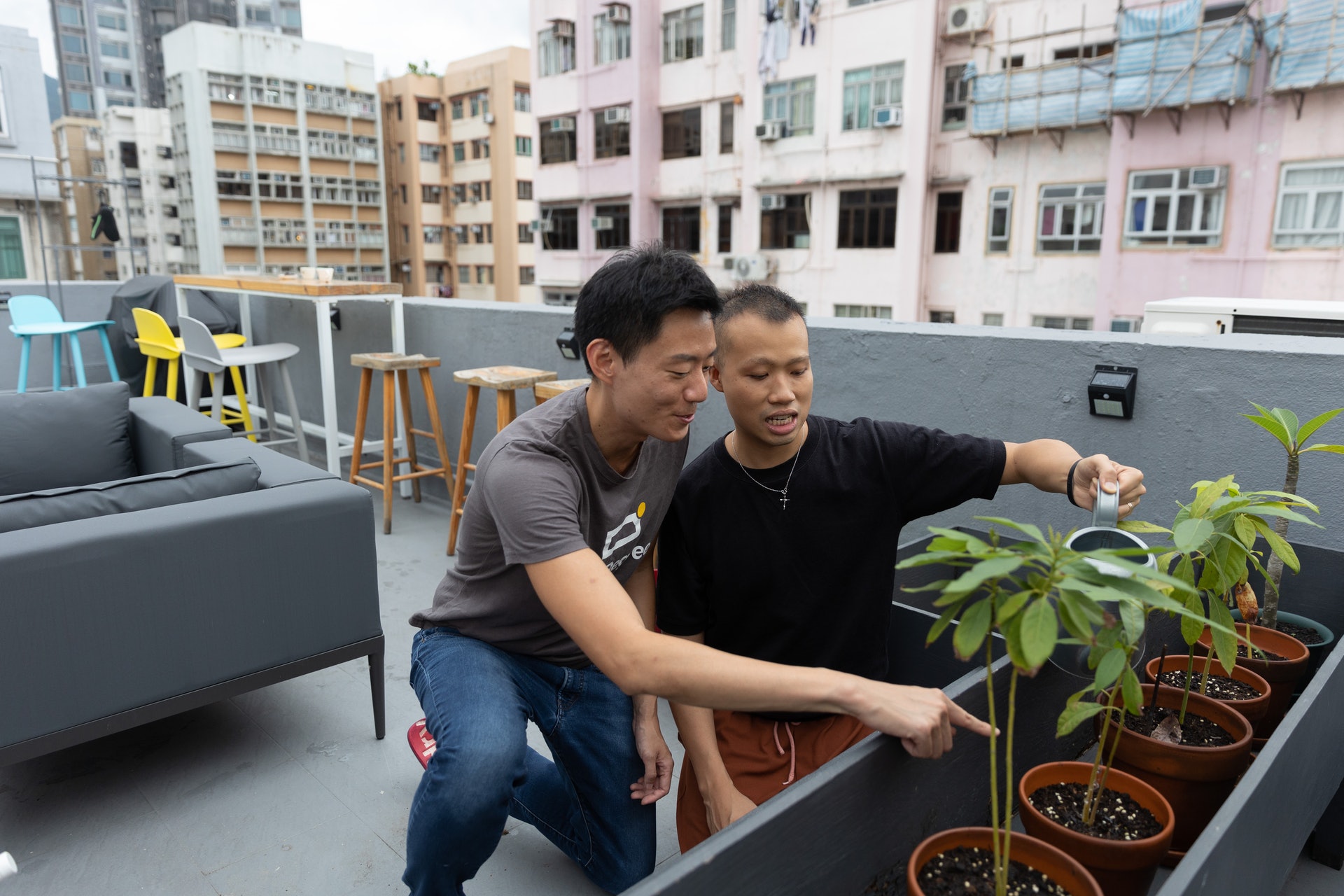 天台上微風吹走悶熱，Alan（左）和阿康（右）閒時又會種菜，他們住的不是甚麼豪宅，家中卻很舒適。（廖雁雄攝）