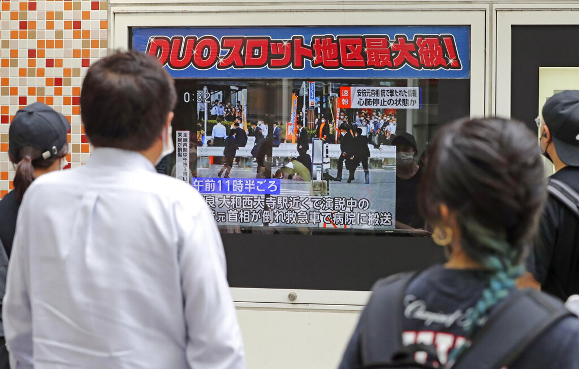 安倍晉三遇刺：圖為日本東京民眾在街上觀看電視新聞報道稱，該國前首相安倍晉三2022年7月8日在日本奈良的進行參議院選舉拉票演講時中彈，他已被緊急送院。（AP）