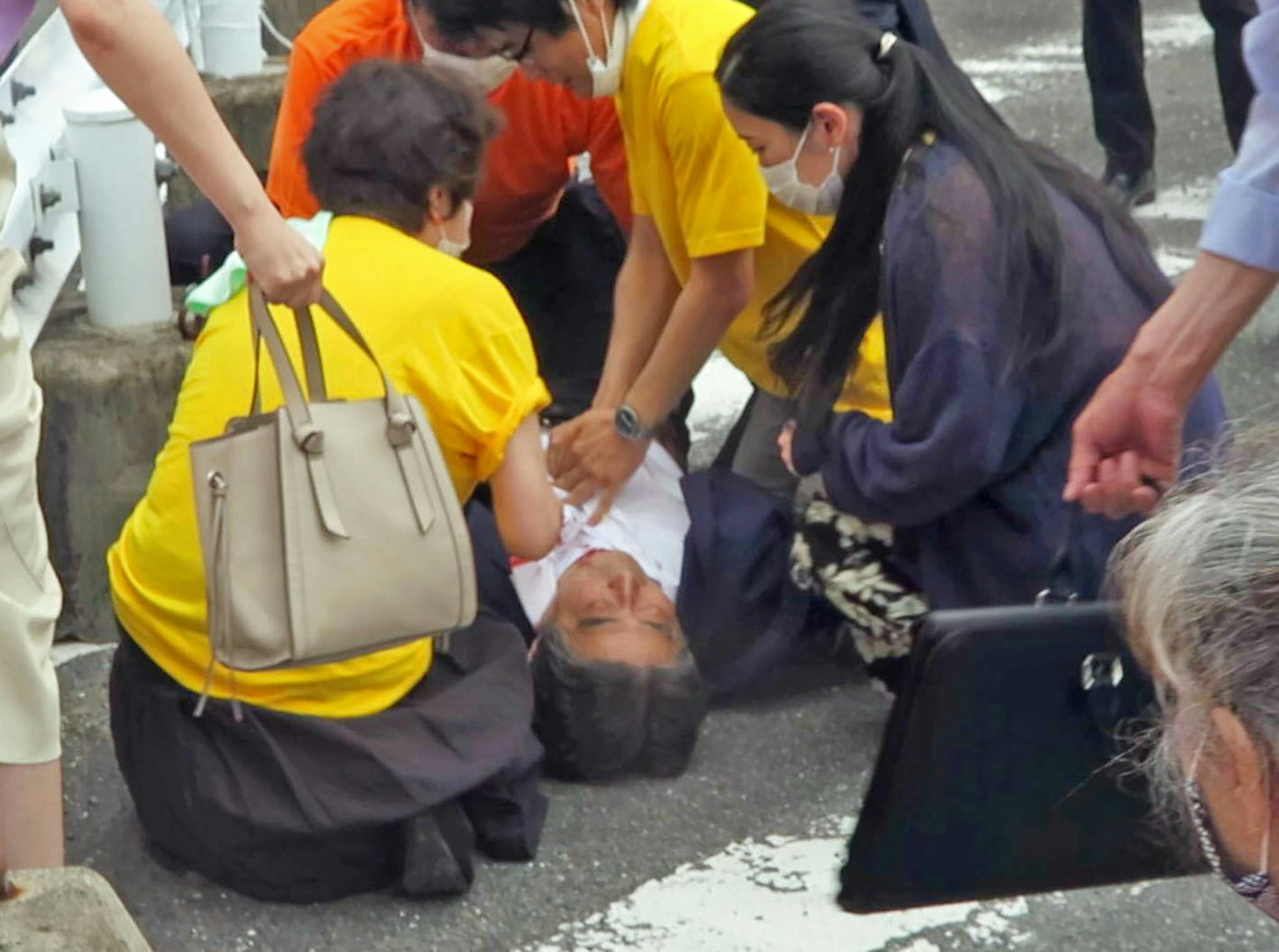 安倍晉三遇刺:日本前首相安倍晉三2022年7月8日早上在奈良近鐵大和西大寺站外進行拉票演講時被人開槍射擊,已被送到附近的一家醫院。圖為影片截圖,相中的安倍已中槍倒地,有人在旁確認他的情況。(AP) 安倍晉三遇刺:日本前首相安倍晉三2022年7月8日早上在奈良近鐵大和西大寺站外進行拉票演講時被人開槍射擊,已被送到附近的一家醫院。圖為影片截圖,相中的安倍已中槍倒地,有人在旁確認他的情況。(AP)