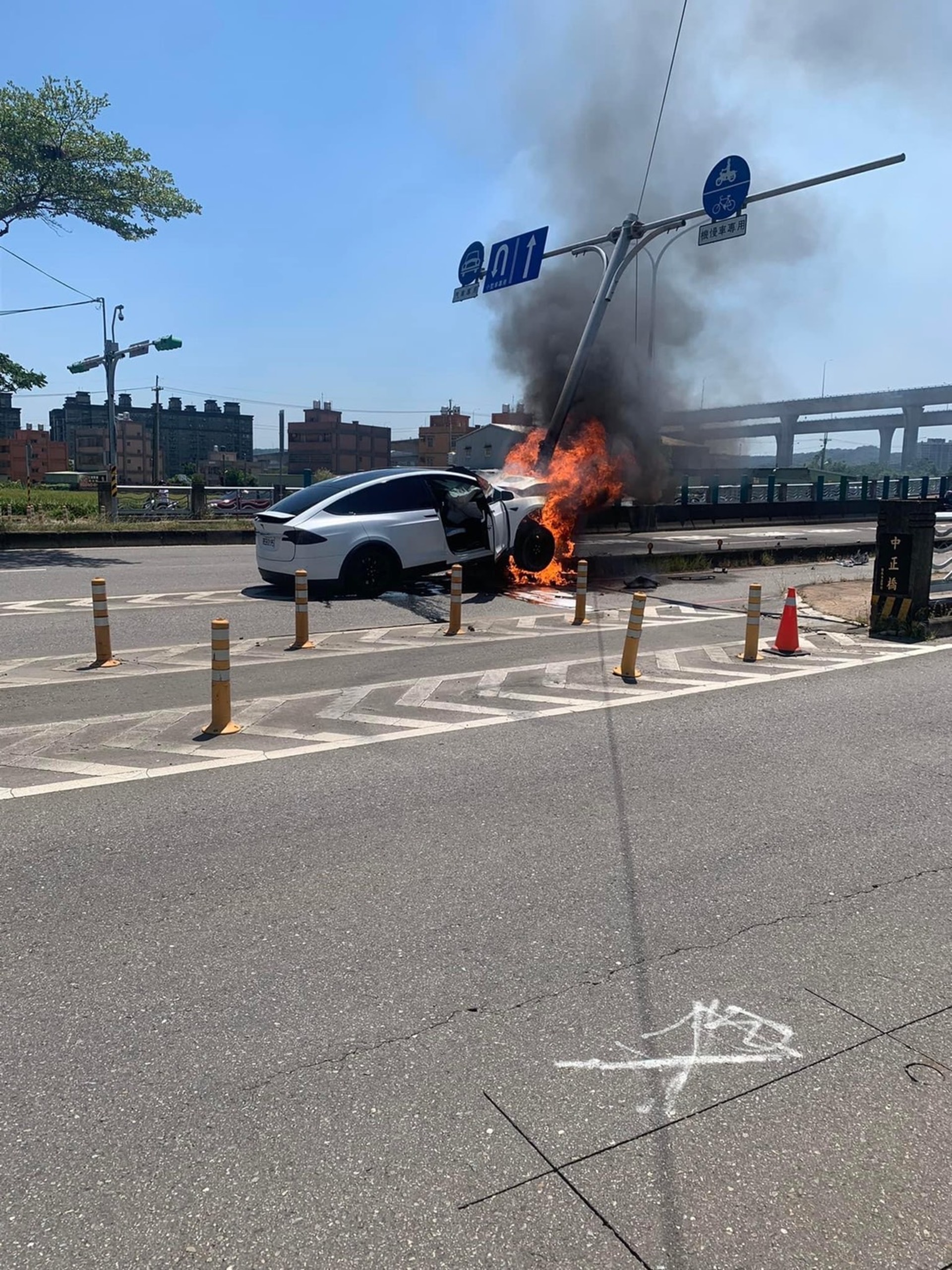 林志穎的Tesla座駕失控撞上安全島的號誌桿，現場冒出熊熊大火。（自記者爆料網）