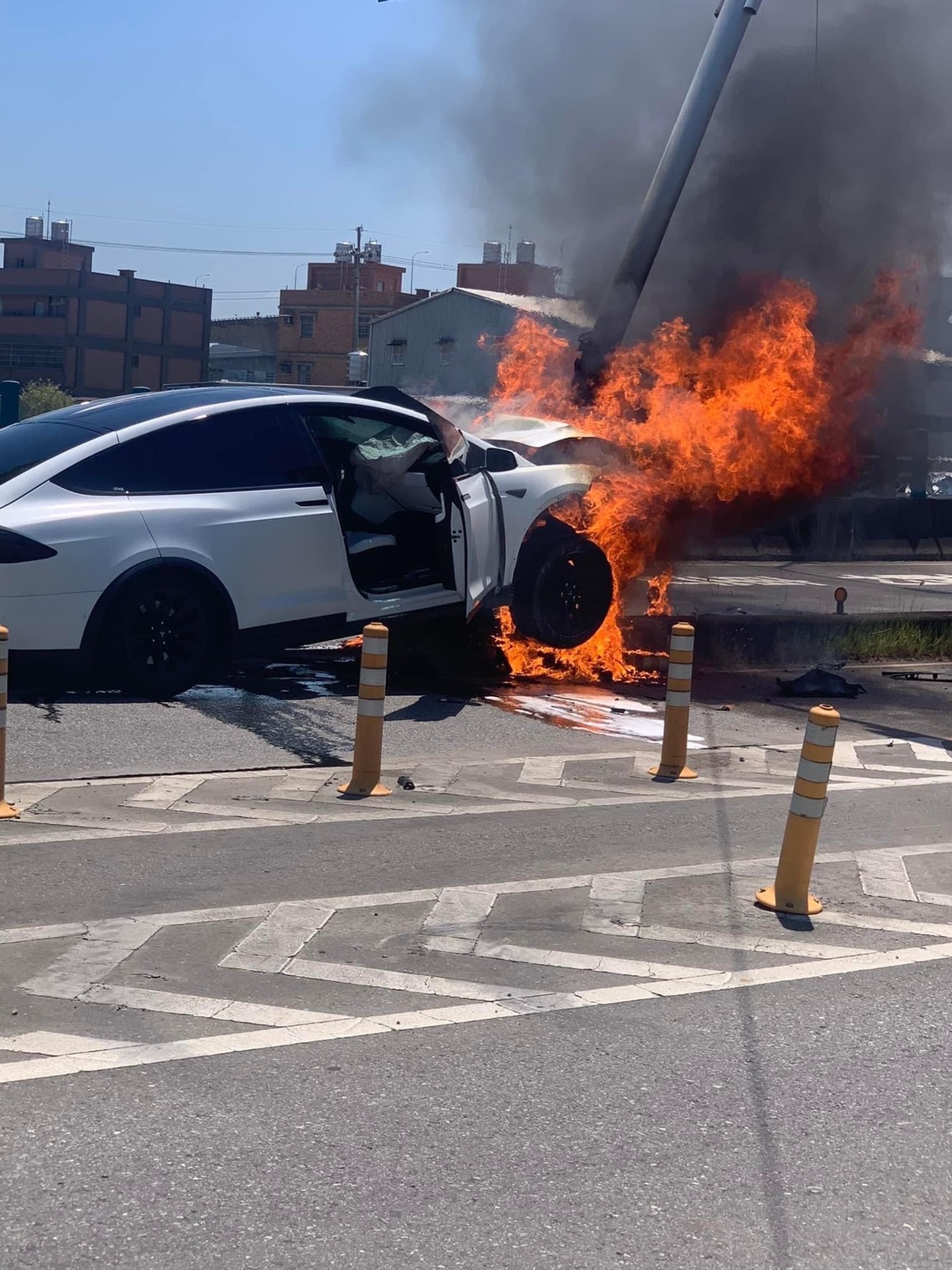林志穎的Tesla座駕失控撞上安全島的號誌桿，現場冒出熊熊大火。（自記者爆料網）