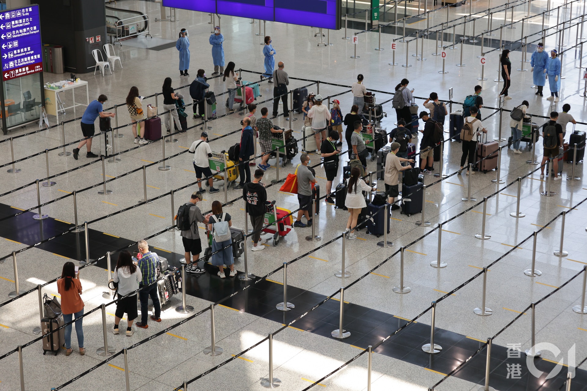 乘搭飛機返港人數在暑假日漸增多,7月25日有大批人士在抵港層,等候乘搭專車往檢疫酒店。(蘇煒然攝) 乘搭飛機返港人數在暑假日漸增多,7月25日有大批人士在抵港層,等候乘搭專車往檢疫酒店。(蘇煒然攝)