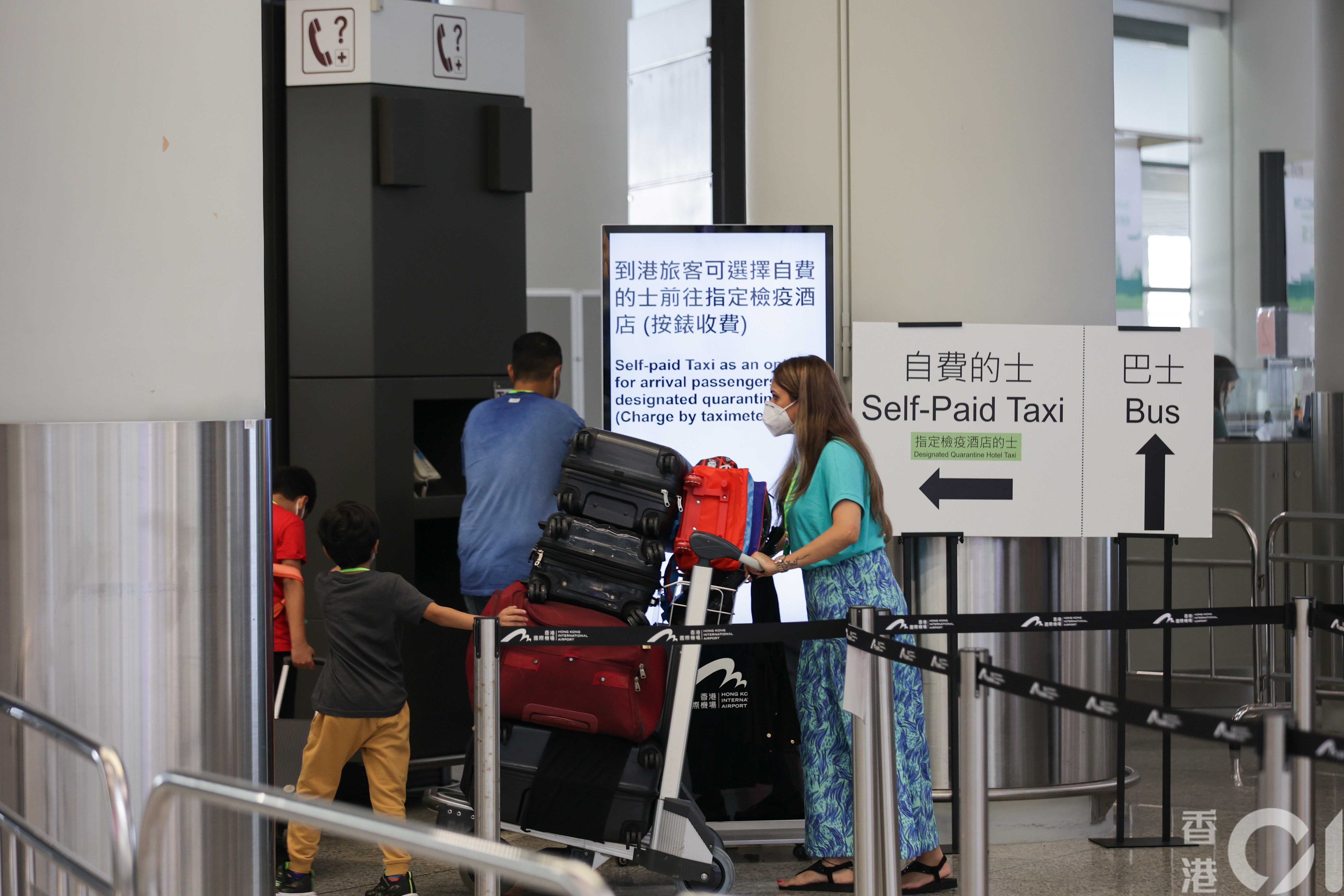 乘搭飞机返港人数在暑假日渐增多，7月25日有大批人士在抵港层，等候乘搭专车往检疫酒店。（苏炜然摄）