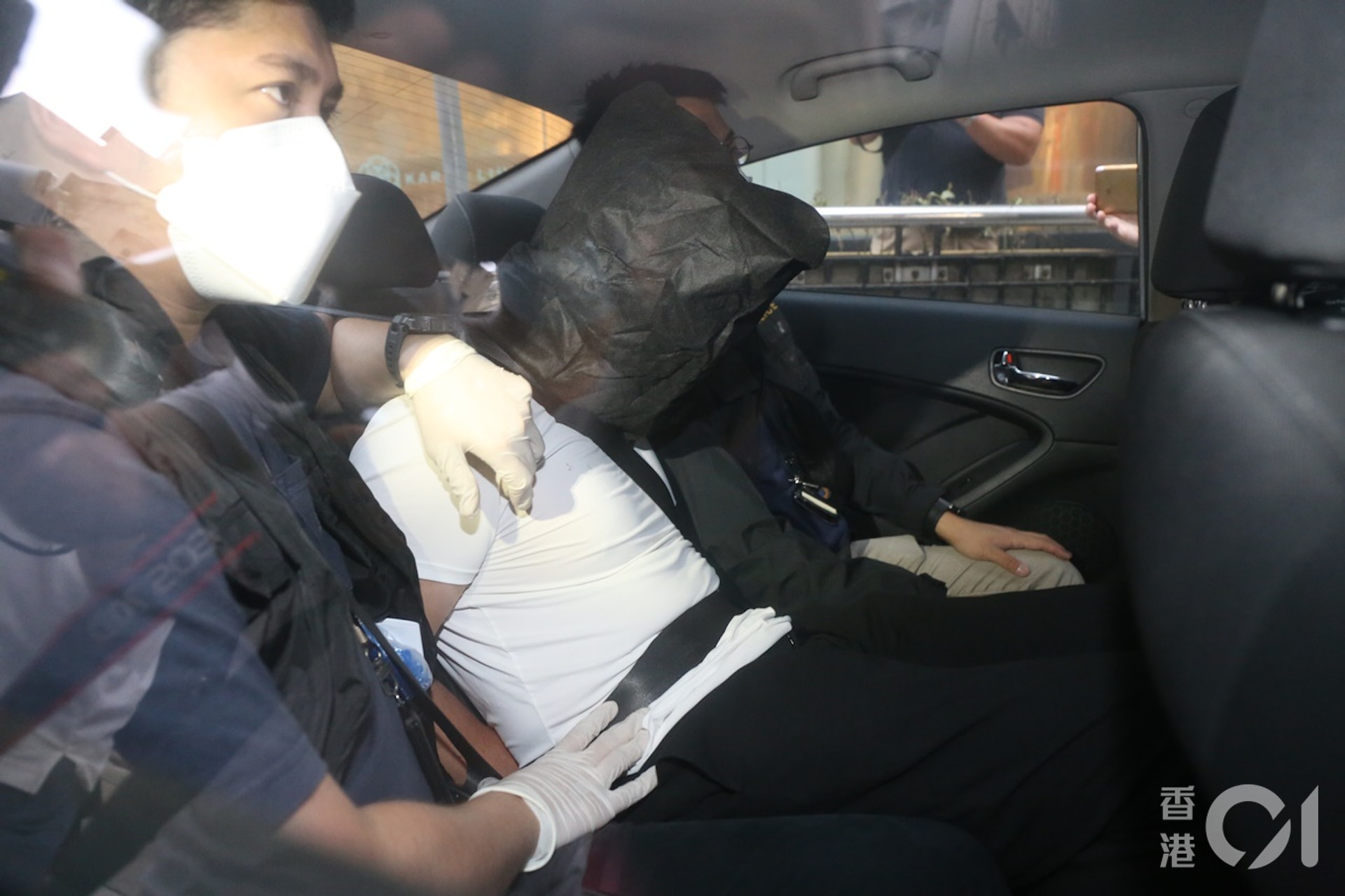 被捕男子遭黑布蒙頭帶署。(張家豪攝) 被捕男子遭黑布蒙頭帶署。(張家豪攝)