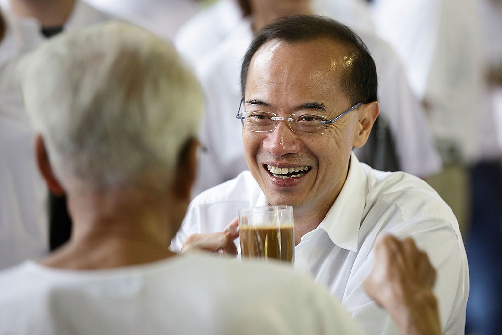 图为2011年5月2日，新加坡人民行动党阿裕尼集选区领军人物、前外长杨荣文在选区落区前，与一名居民一同喝咖啡。2011年5月7日新加坡举行第11届国会选举。（Getty）