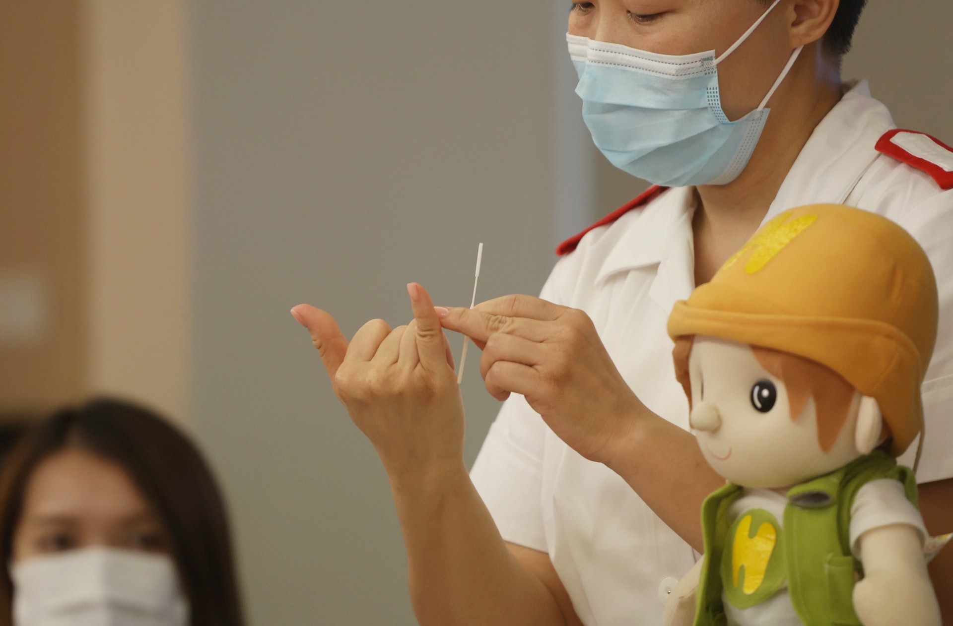 瑪嘉烈醫院資深護師（傳染病中心）陳瑩斐提醒家長為子女快測時並非越入越好，更重要的是在鼻中轉圈，以採集到足夠的分泌物。（余俊亮攝）