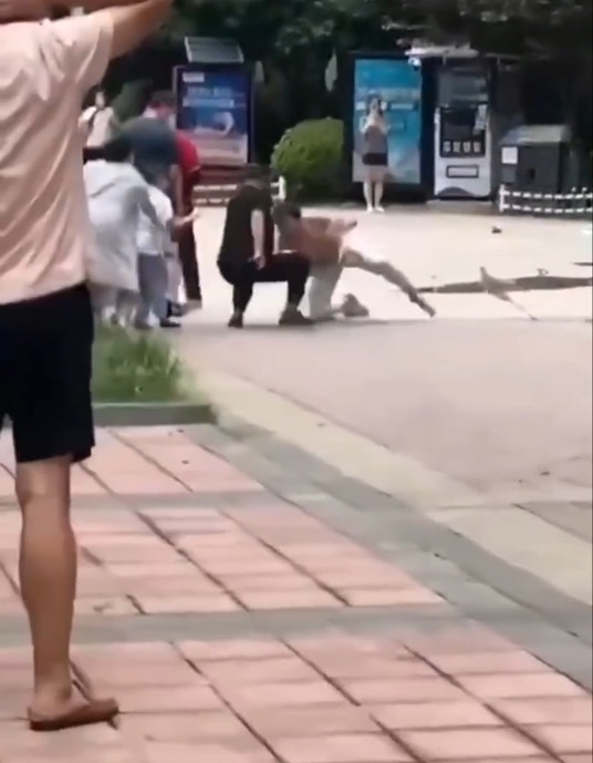 湖北武汉一名疑似精神失常的男子，在小区内趴地学狗叫咬伤2名路人。 （影片截图）