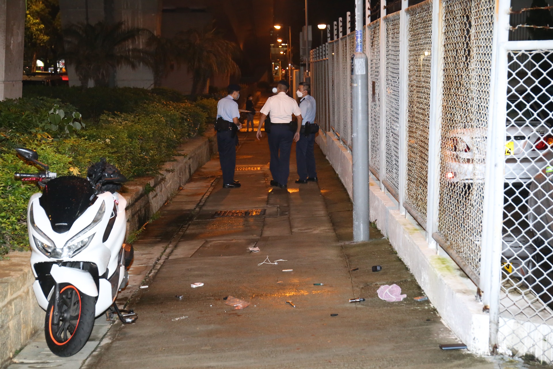 警方調查現場附近一部電單車,地面散落火機、士把拿等物品。(陳浩然攝) 警方調查現場附近一部電單車,地面散落火機、士把拿等物品。(陳浩然攝)