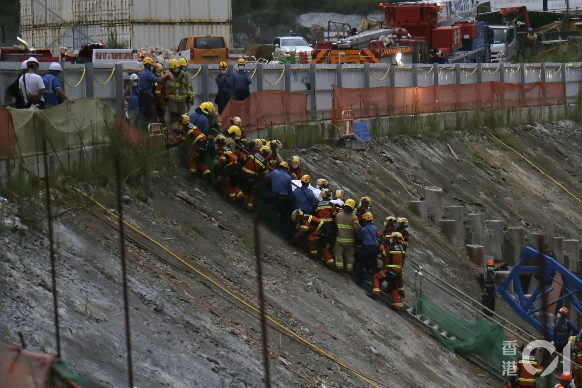 多名消防員及救援人員合力將被困工人抬出。(林朗天攝)
