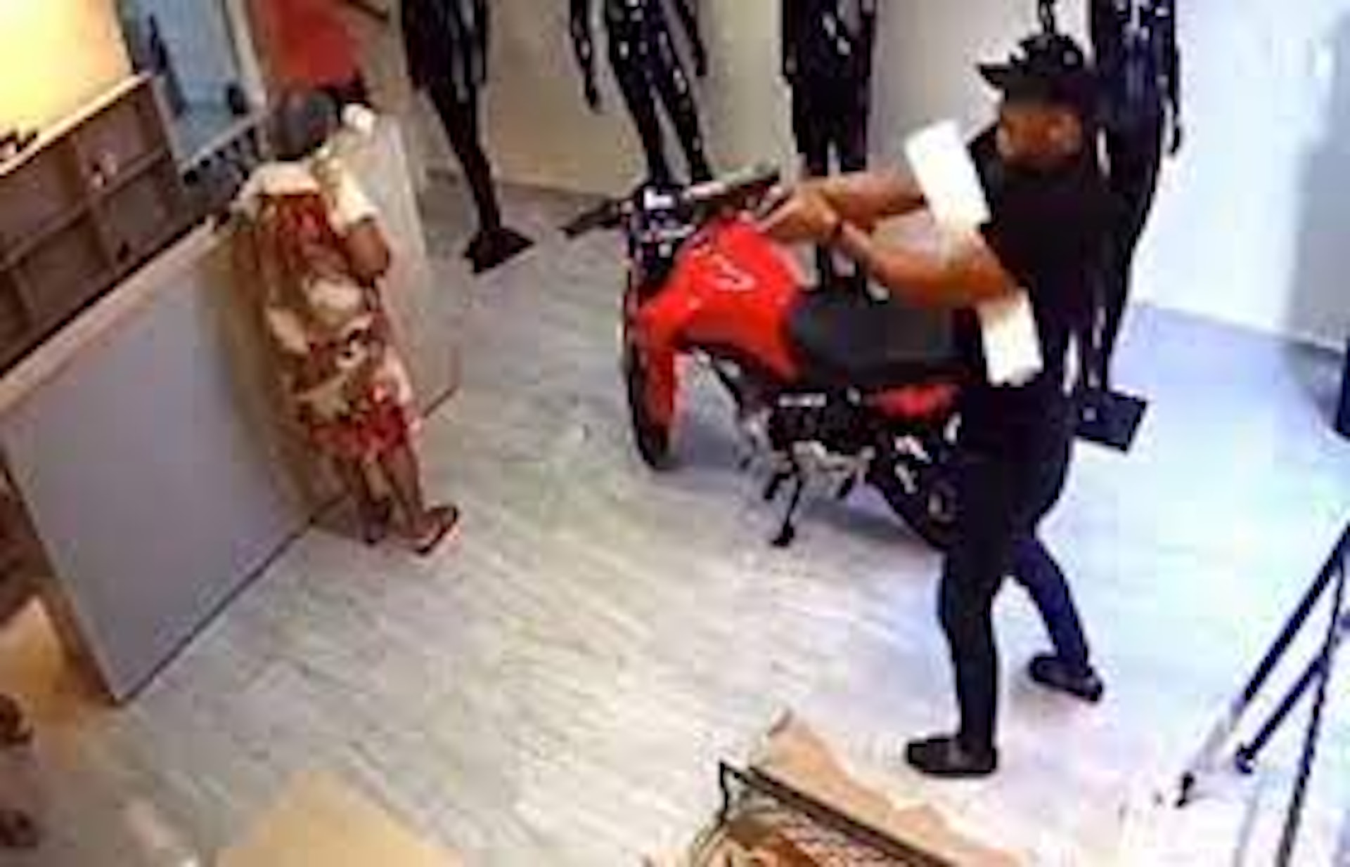 戴黑色帽子的持槍兇徒，用槍指向在另一位女店員賈尼亞（Jania Simplicio），儘管賈尼亞向他求情，仍向她開槍，亦在離開時再向地上的賈尼亞補多一槍。（影片截圖）