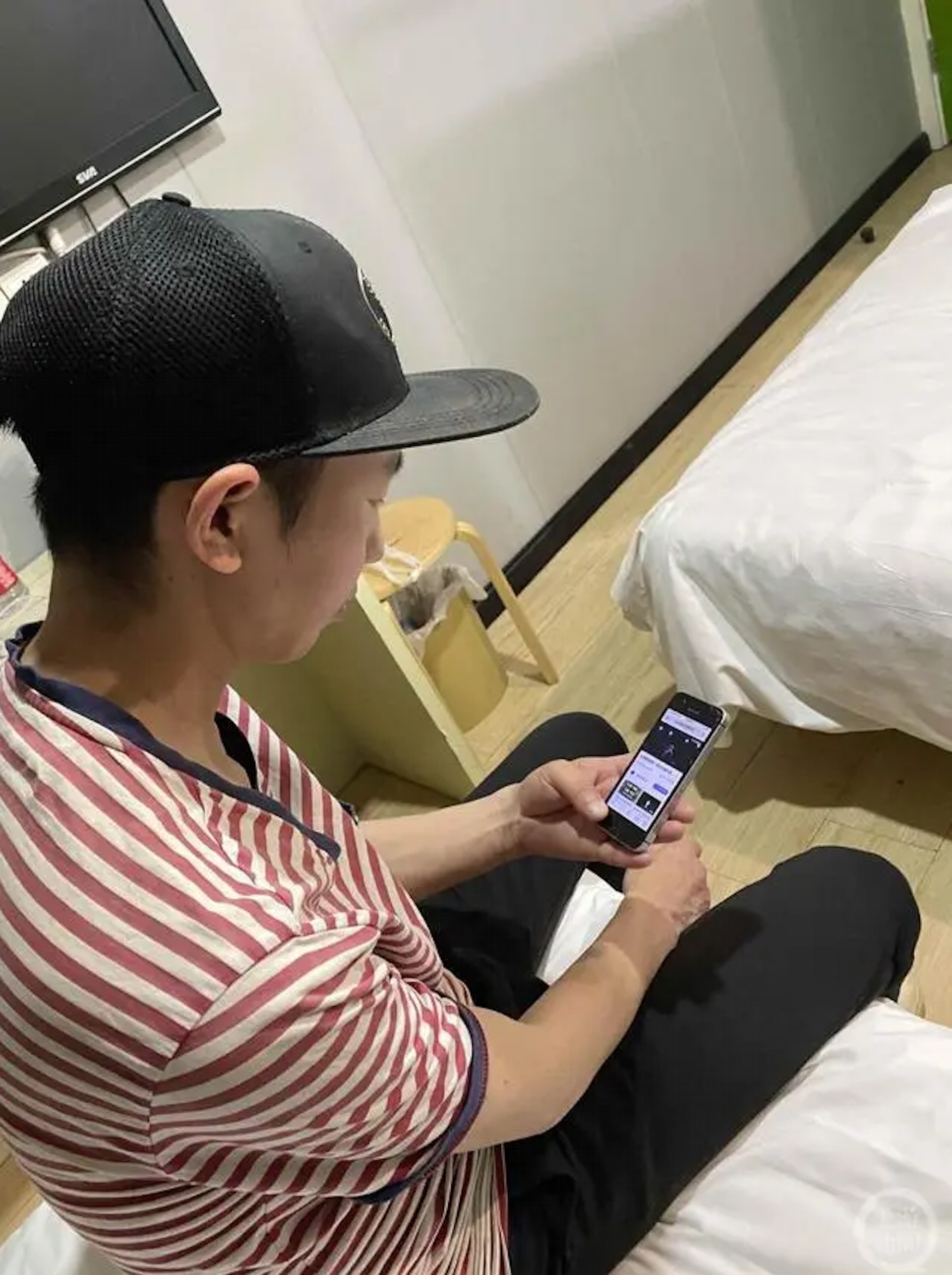 2021年5月，西安一賓館，龐麥郎用手機看自己的演出視頻。（上游新聞）