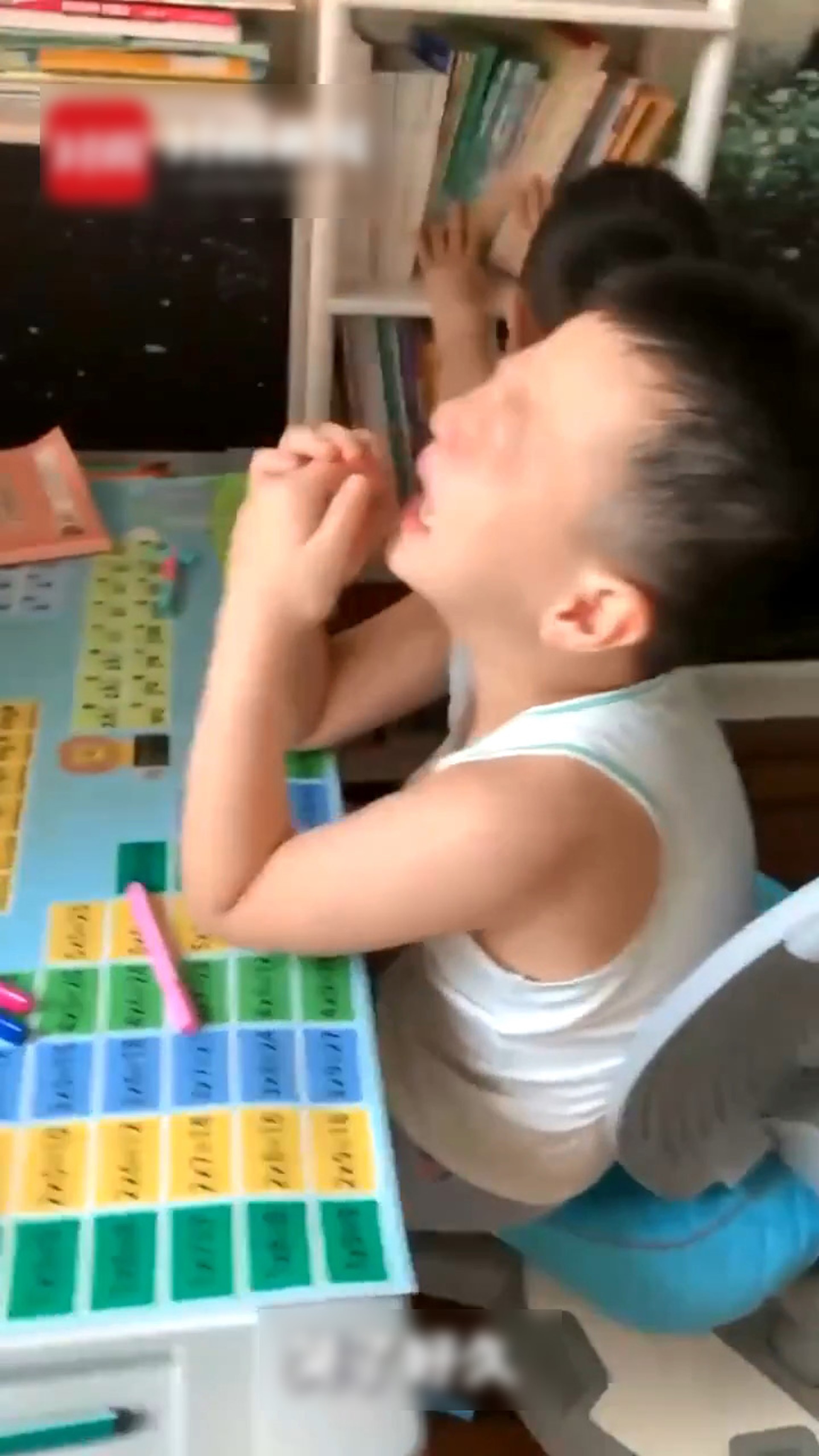 哥哥失聲痛哭,弟弟玩弄旁邊的書架。(微博影片截圖) 哥哥失聲痛哭,弟弟玩弄旁邊的書架。(微博影片截圖)