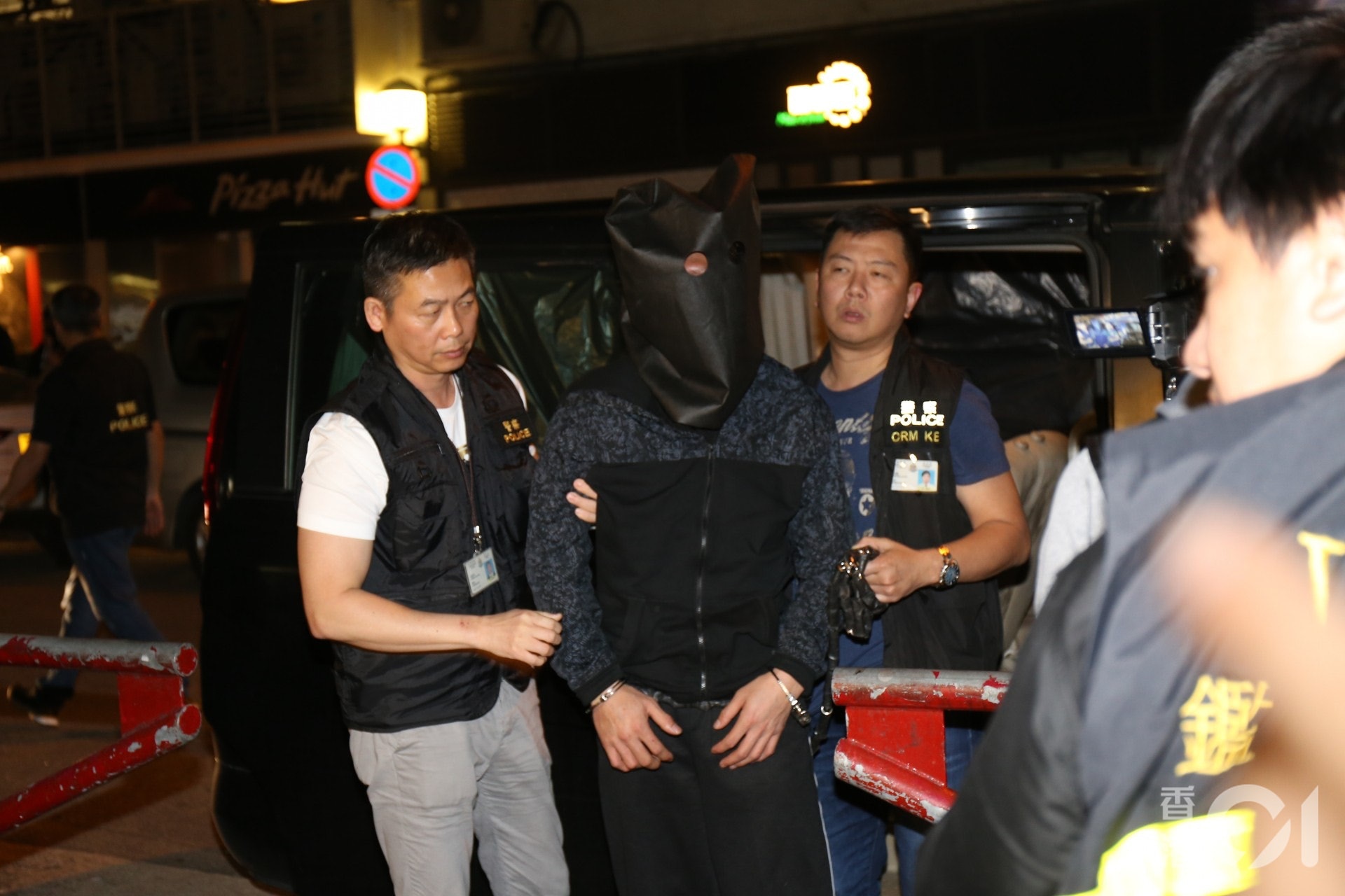 被告羅偉文(黑布蒙頭者)否認謀殺，但承認誤殺罪，但不被控方接納，案件在高等法院開審。(資料圖片)
