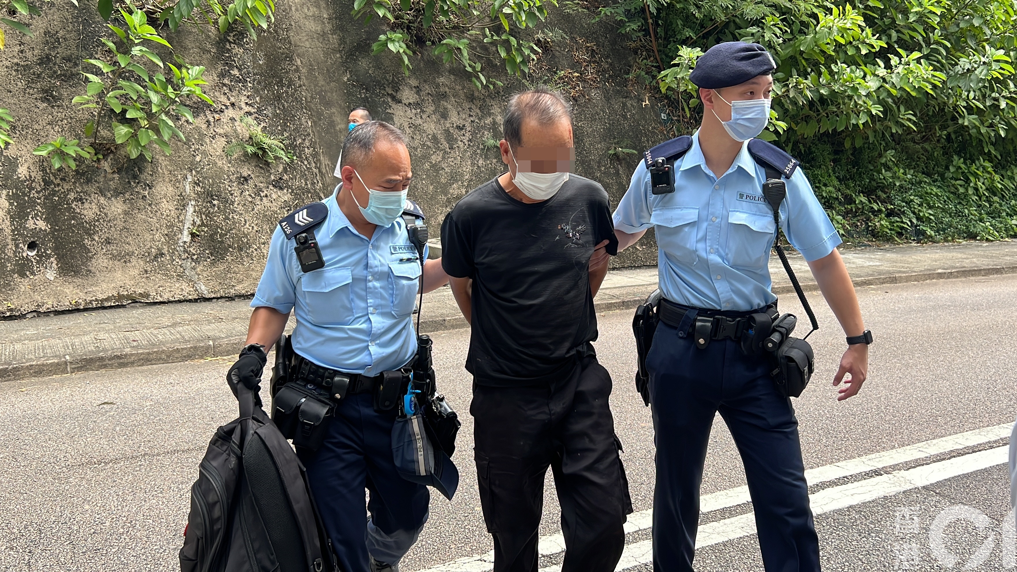 疑犯被雙手反鎖身後。（翁鈺輝攝）