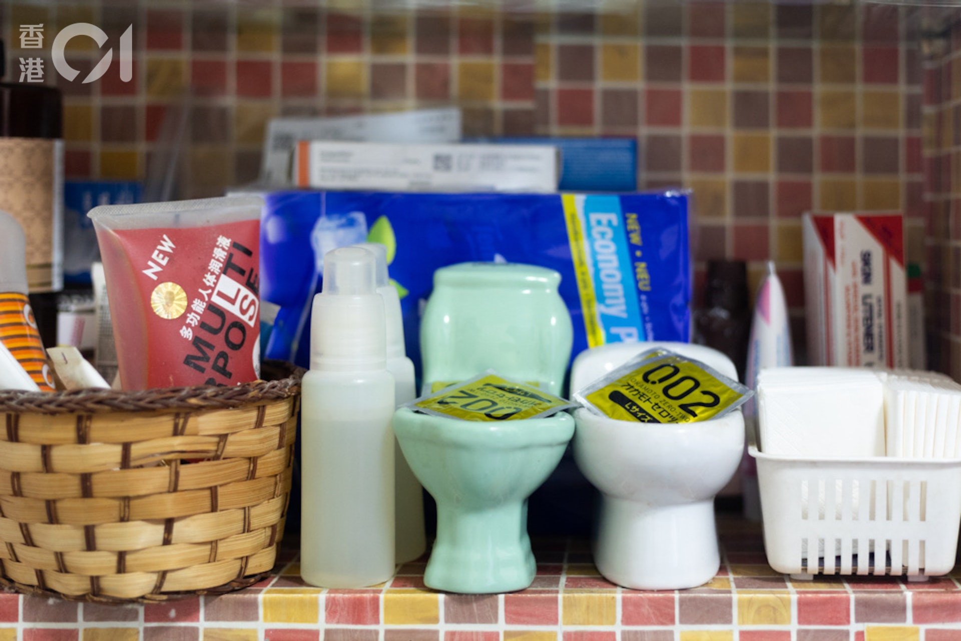 David的工作室牆上有四層置物架,下面兩層放置精油、安全套等。(余俊亮攝)