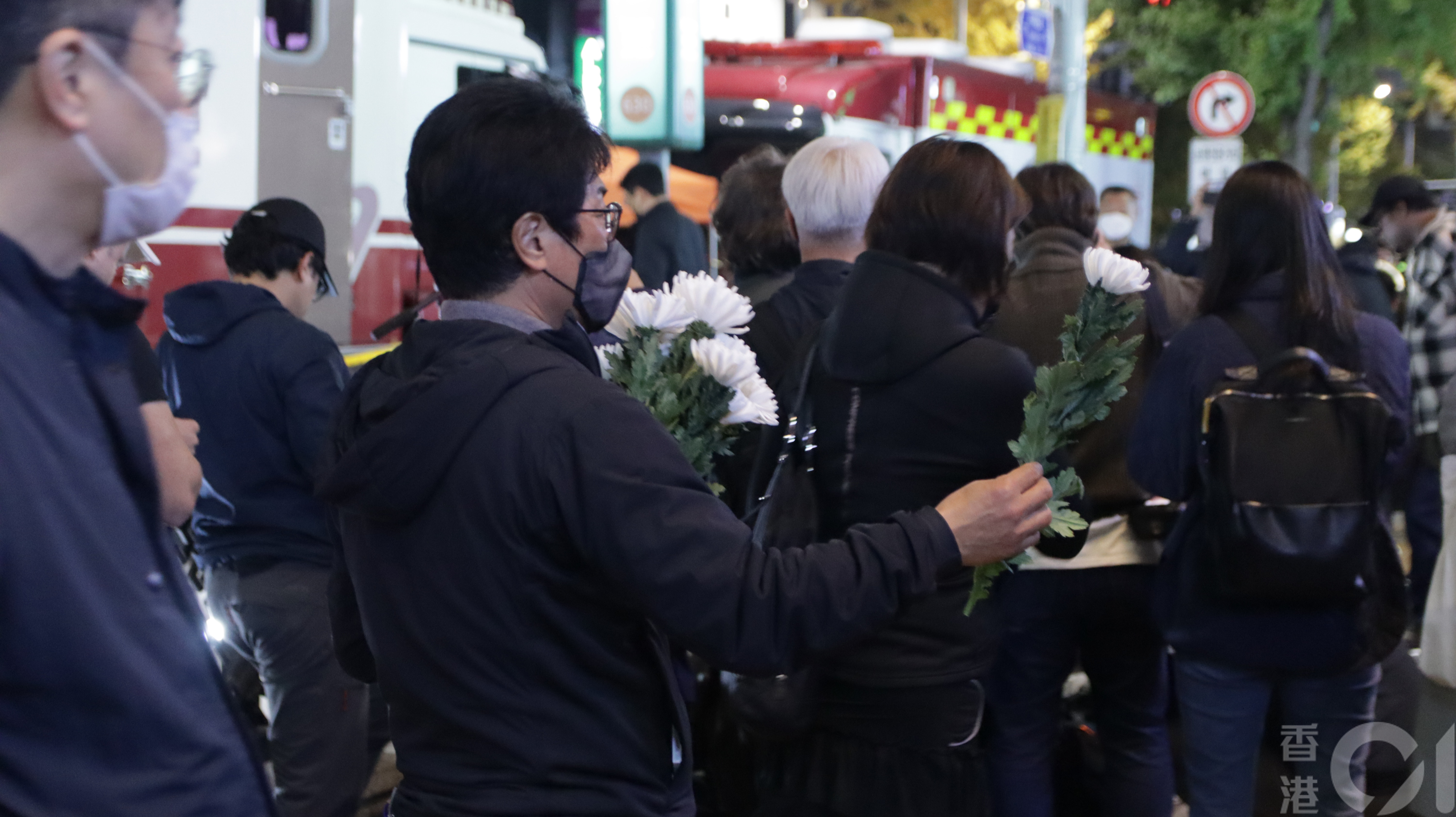10月30日韓國梨泰院萬聖節人踩人慘劇翌日，現場圍封，有當地居民在場白菊花予悼念人士。（特約記者施可瑩攝）