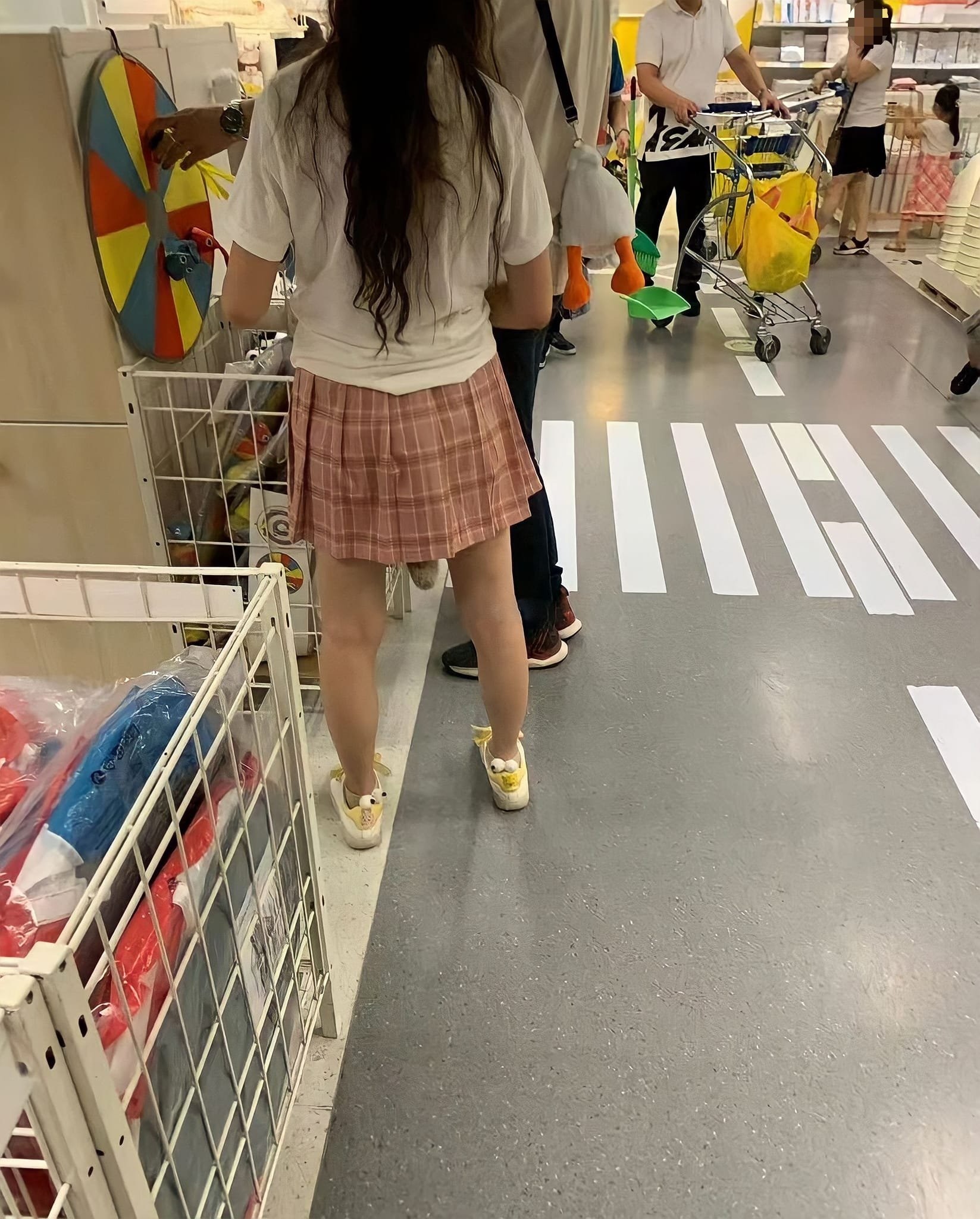 當中的女孩子穿著白上衣搭配粉紅格子短裙，但怪的是從裙子下方竟然露出一小截「尾巴」，原PO看了笑說「快上廁所吧……便便快掉下來了」。（Facebook@爆廢公社公開版）