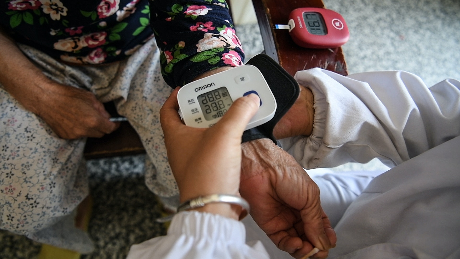 在融安縣長安鎮隘面村，王雪丹上門為一名老人測量血壓。（新華社）