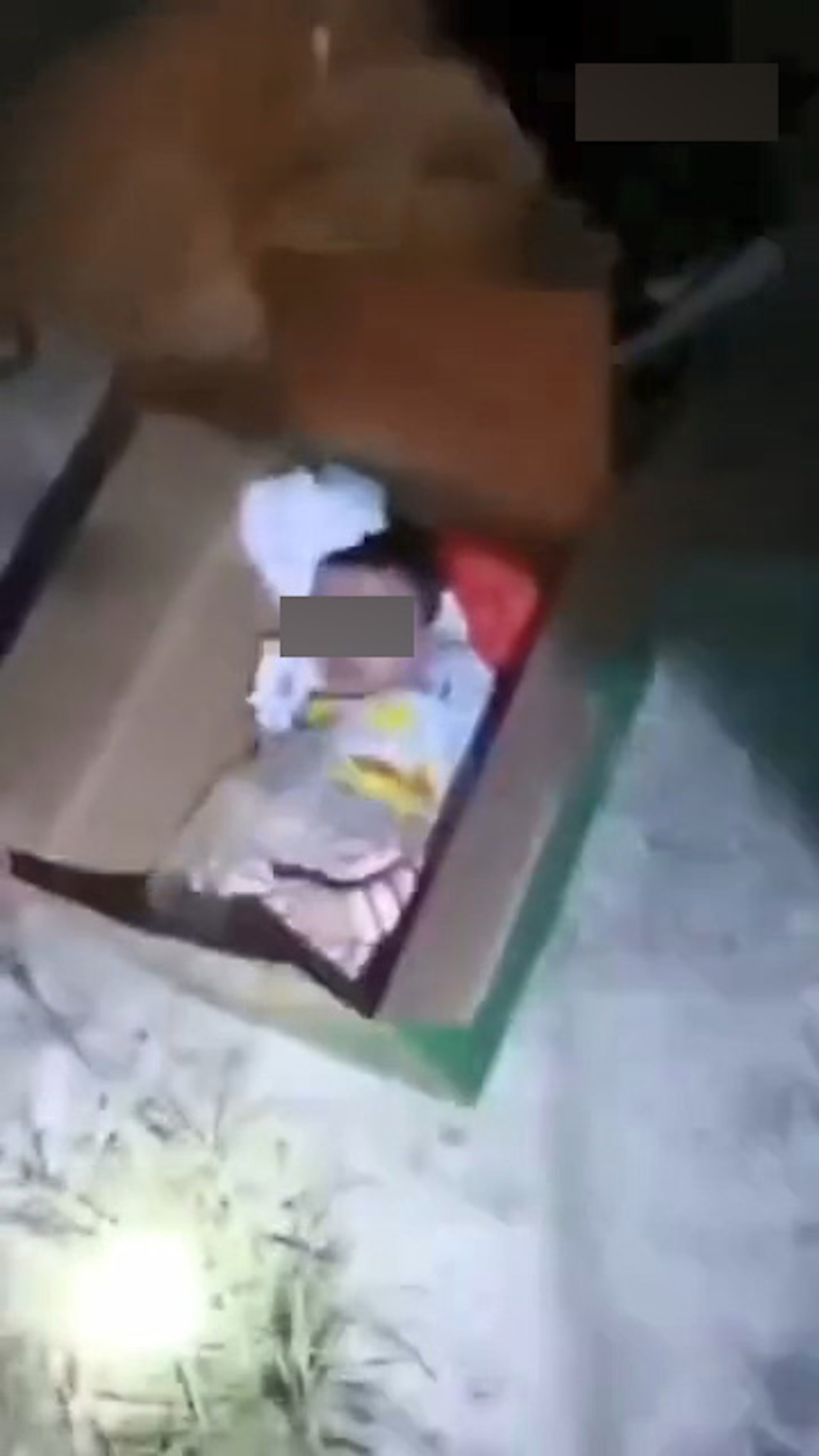 寶寶被放入一個尺寸和他差不多大的紙箱，餐面還放有衣物。（微博影片截圖）
