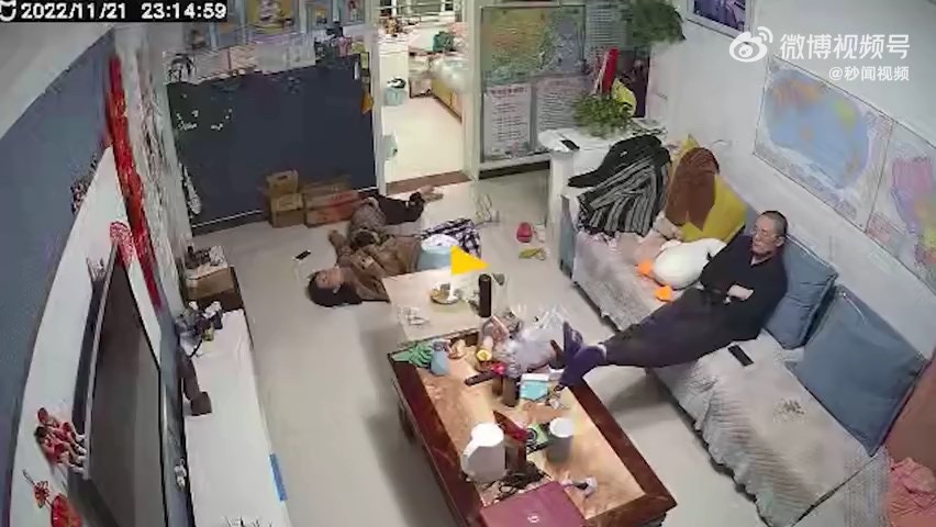 内地河南郑州一名人妻近日突然昏倒在地，惟在旁的丈夫竟然只瞄了一眼就继续看电视，无动于衷。（影片截图）