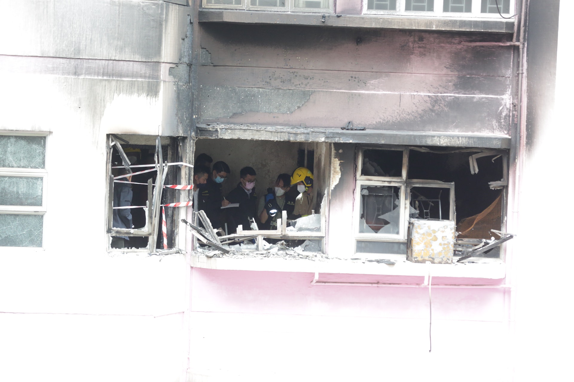 今日(1日)上午消防員與警員登上起火單位調查,以圖查出事件始末。(黃偉民攝)