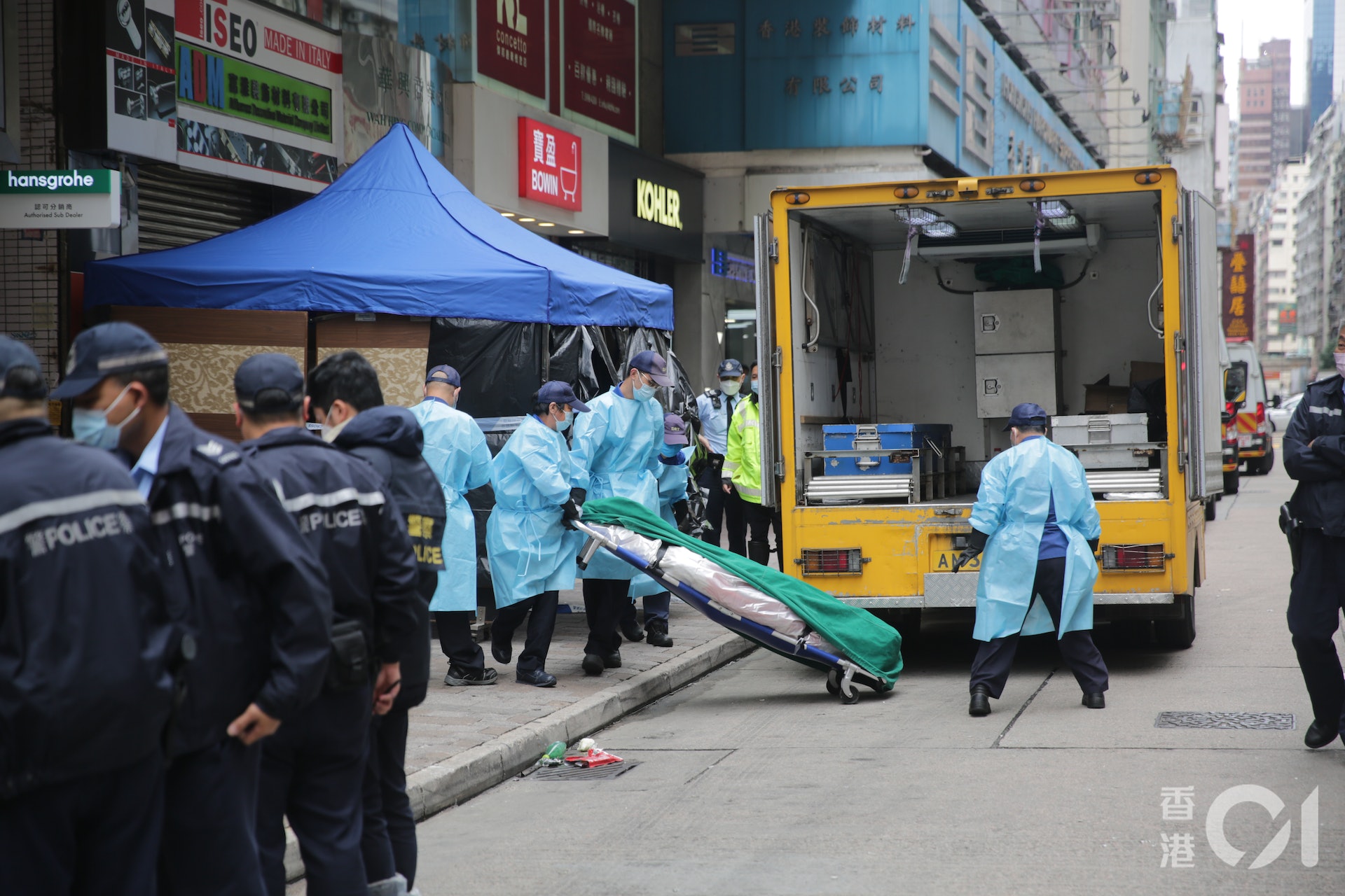 下午12時許,仵工將屍體舁送殮房。(黃偉民攝)